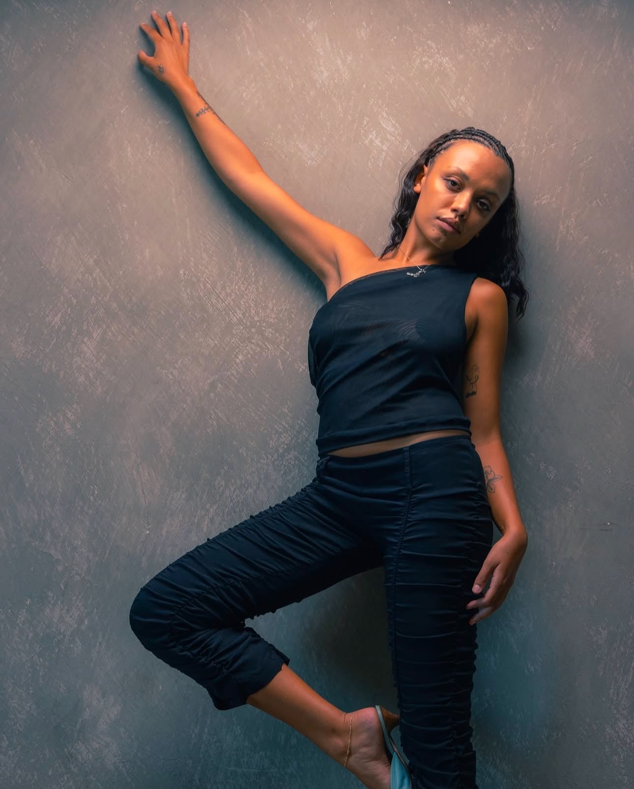 A model wearing the black city tank in an aesthetically background. 100% made from sustainable deadstock materials.