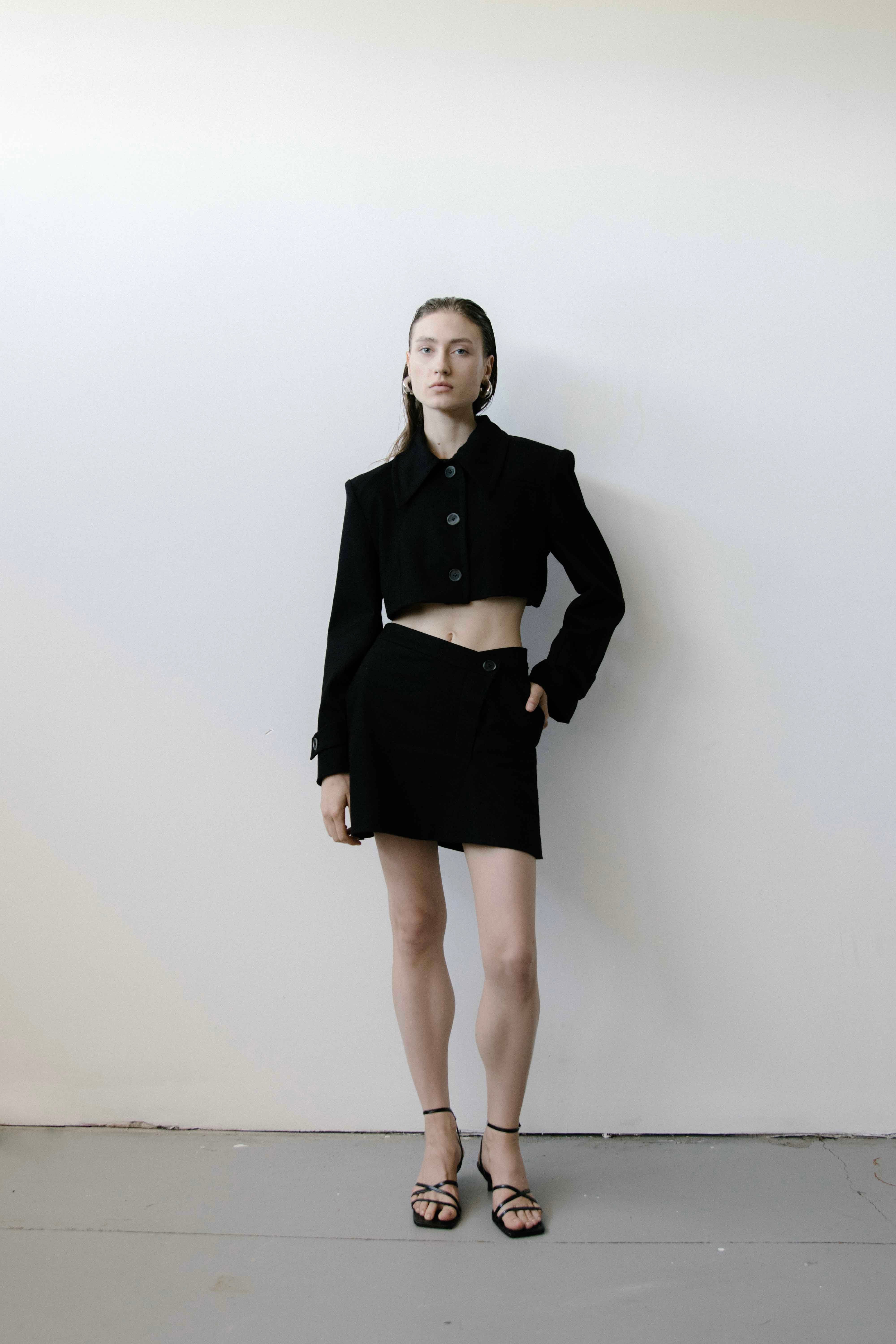 A model wearing the triangle black skirt in a white background. 100% made from organic cotton.