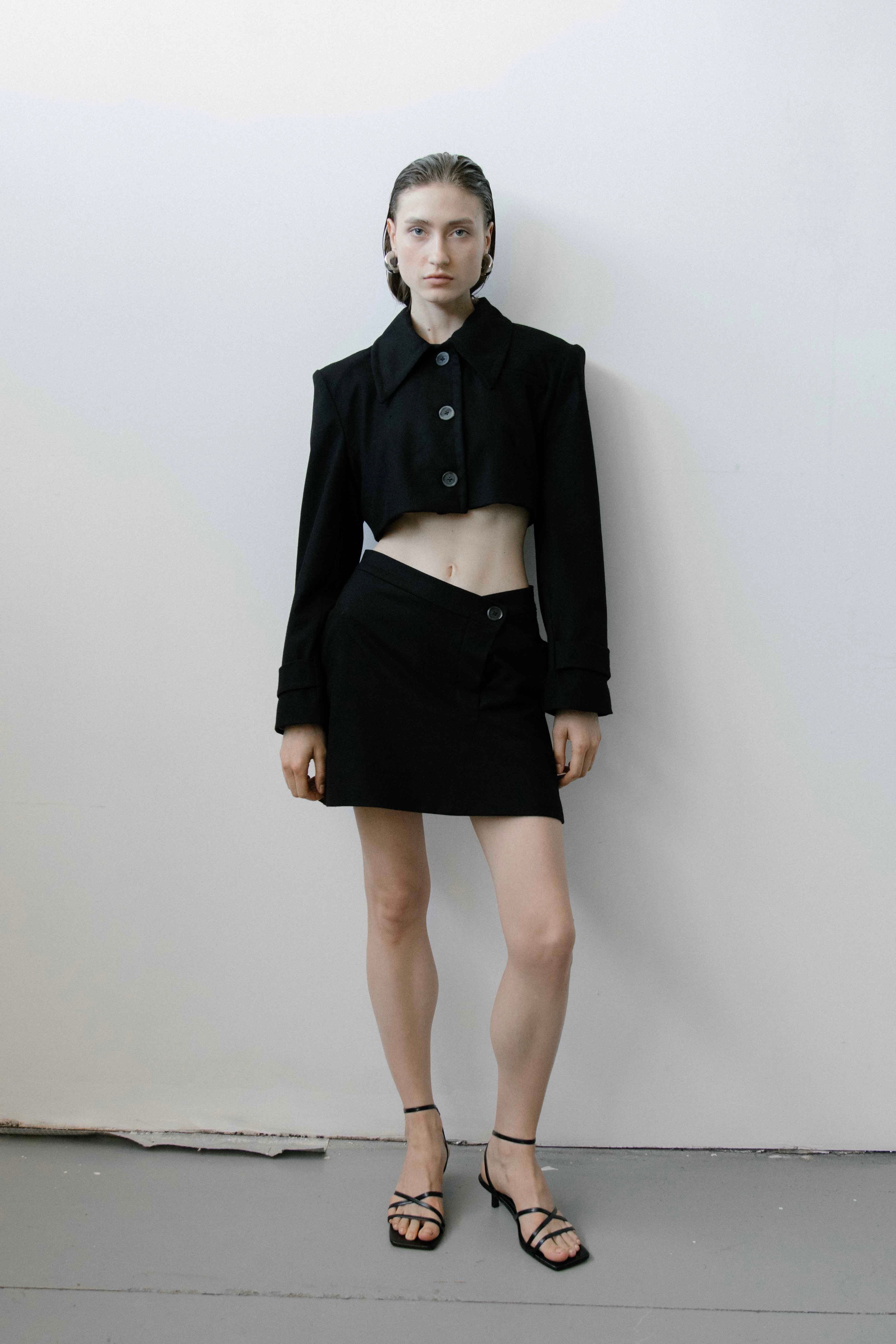 A model wearing the triangle black skirt in a white background. 100% made from organic cotton.