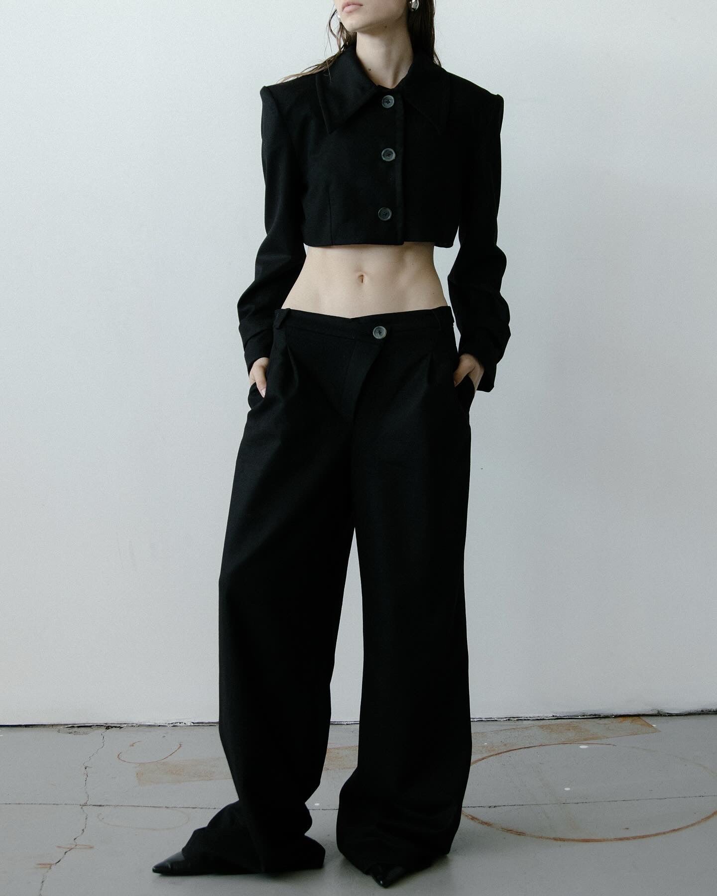 A model wearing the triangle black trouser in a white background. 100% made from mulesing-free merino wool.