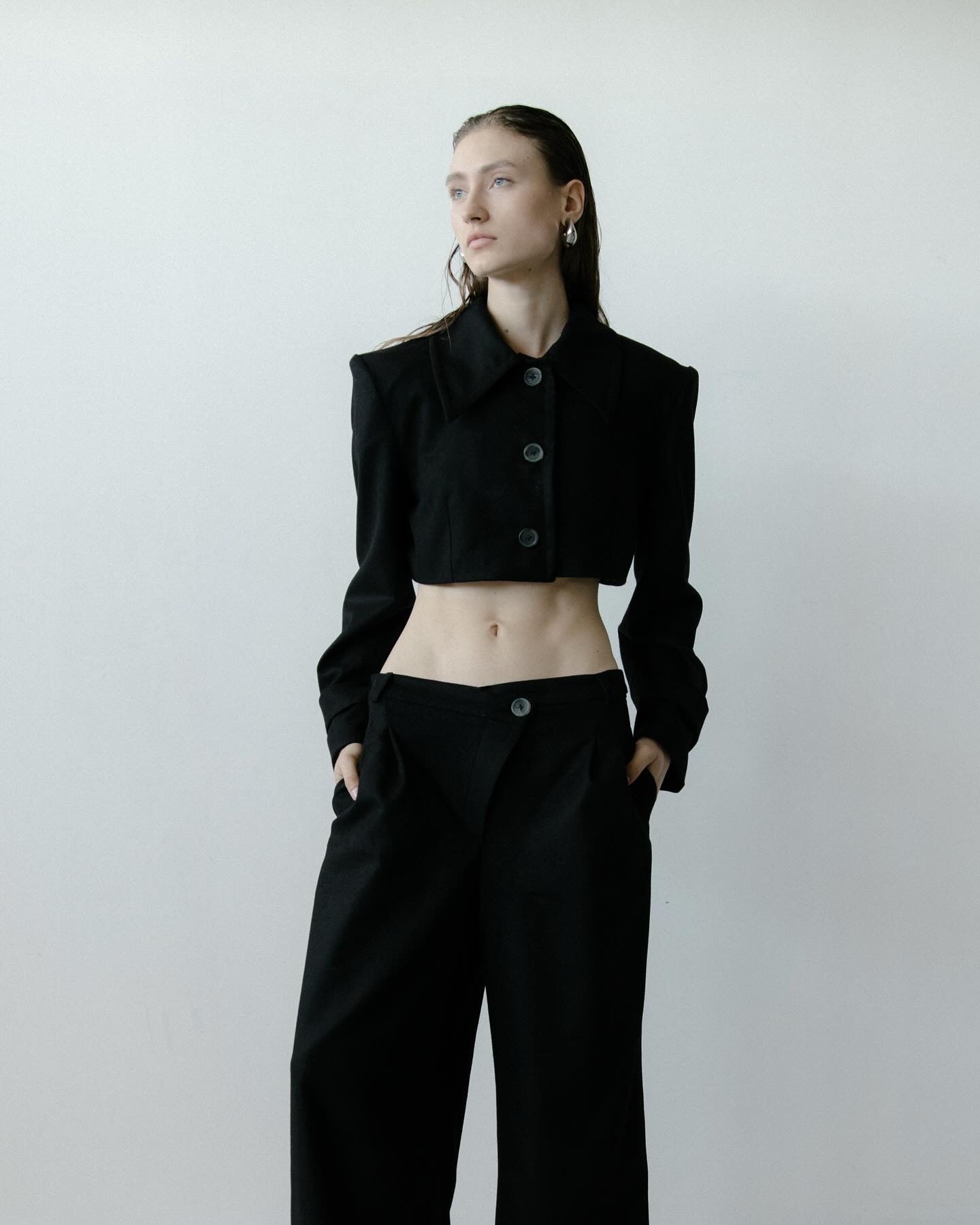 A model wearing the triangle black trouser in a white background. 100% made from mulesing-free merino wool.