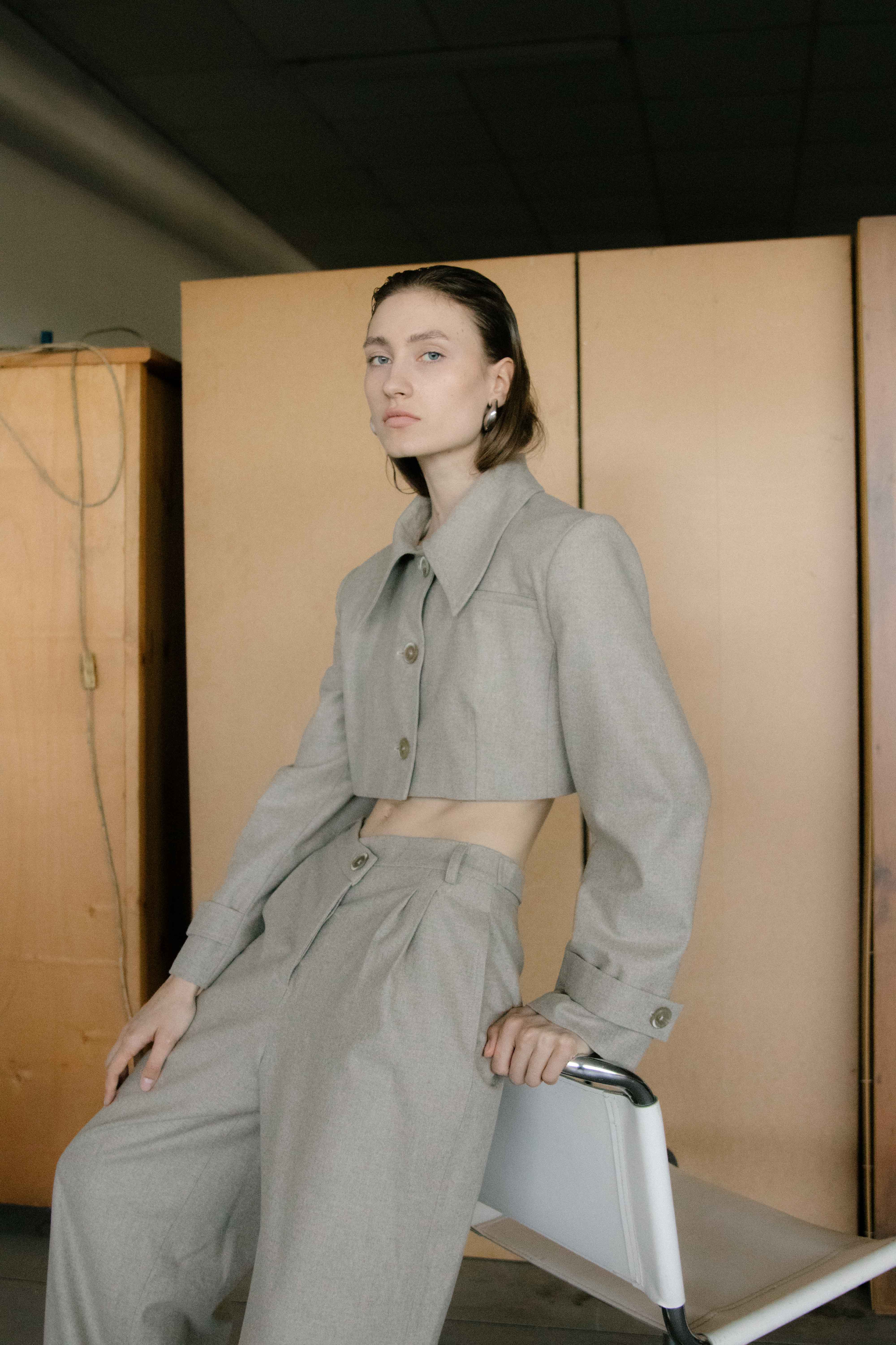 A model wearing the triangle taupe trouser in an aesthetically background. 100% made from mulesing-free merino wool.