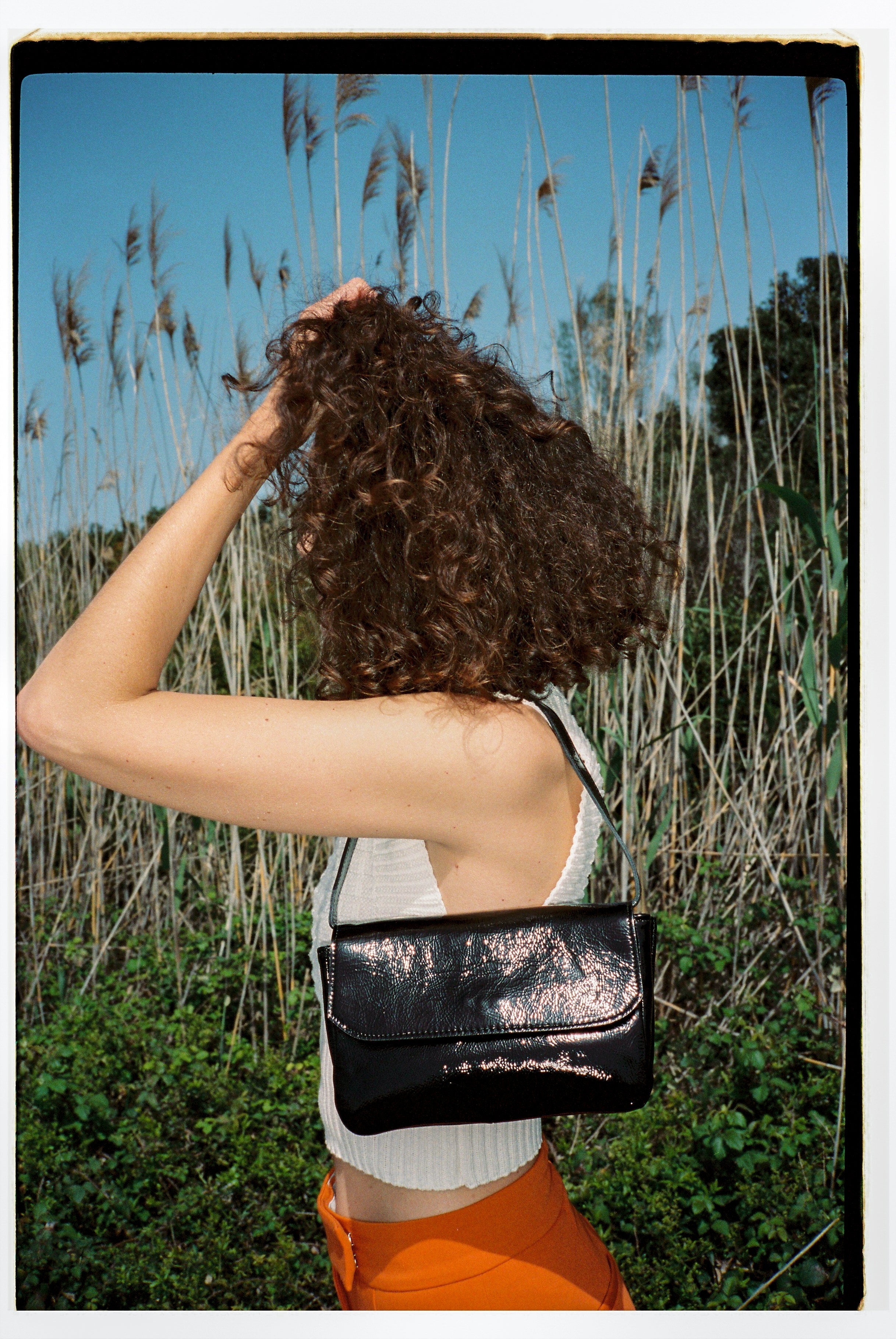 A model wearing the babe black bag in an aesthetically background. 100% made from deadstock leather.