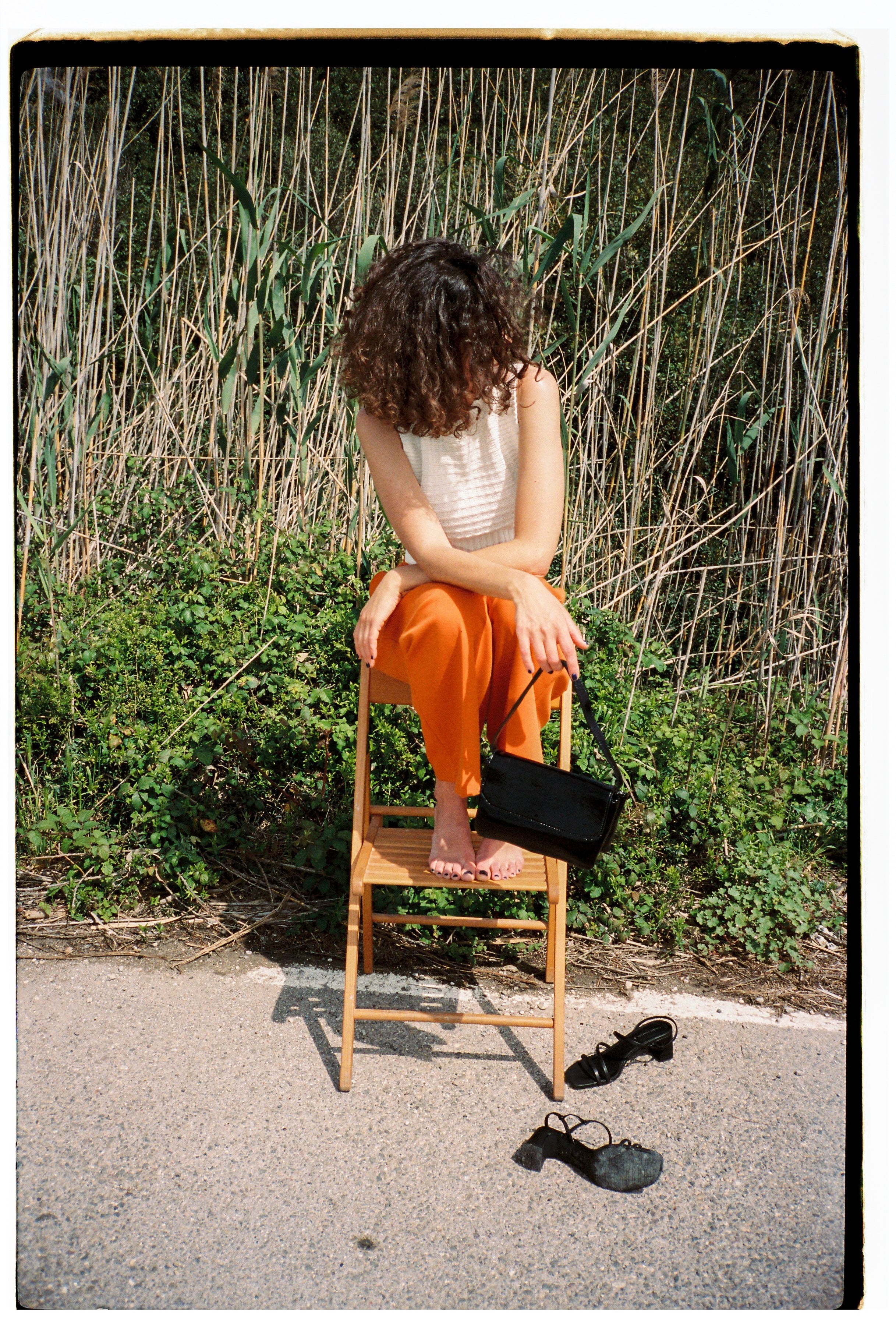 A model wearing the babe black bag in an aesthetically background. 100% made from deadstock leather.