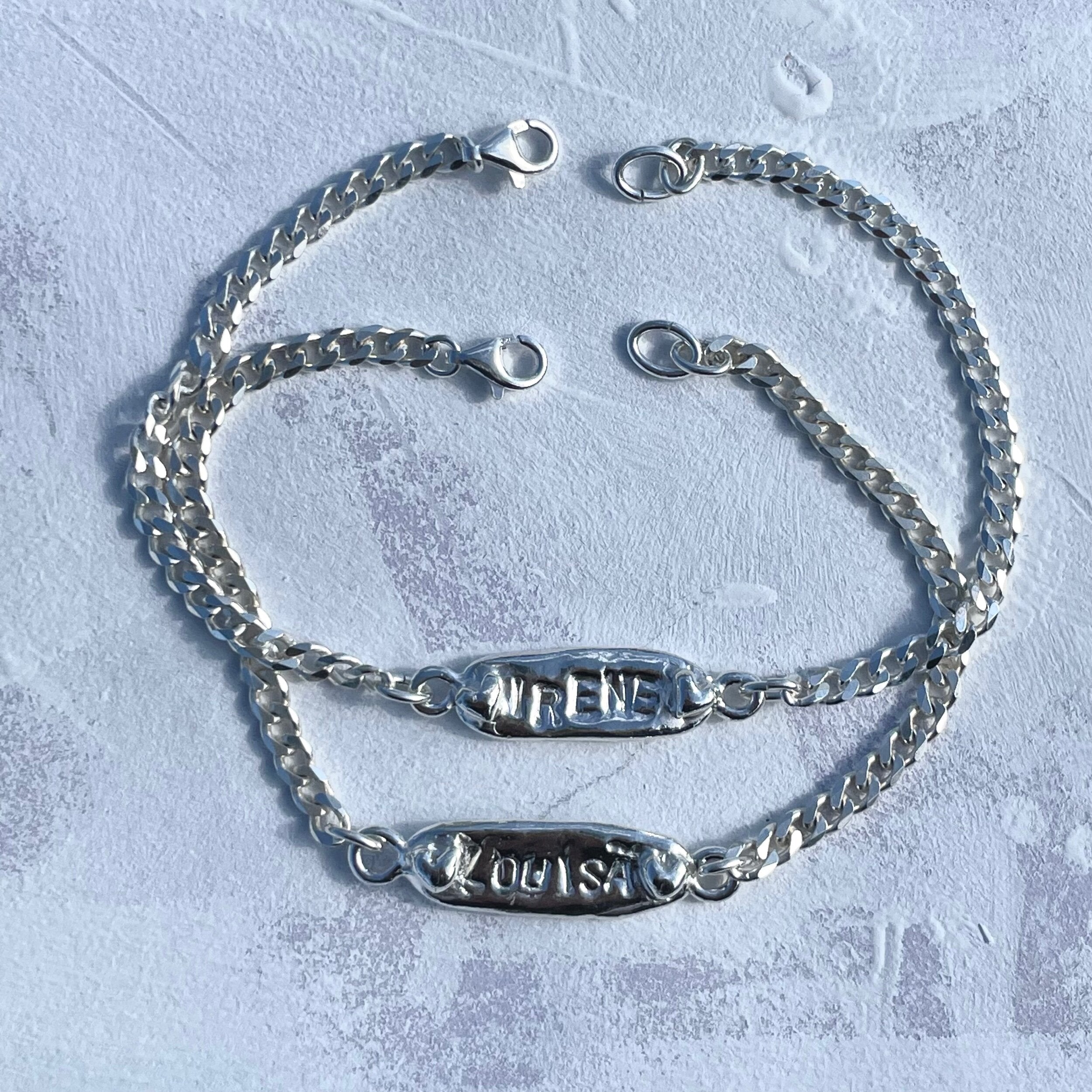 The custom name bracelet in a white background. Made from 100% recycled metals and lab created gemstones.