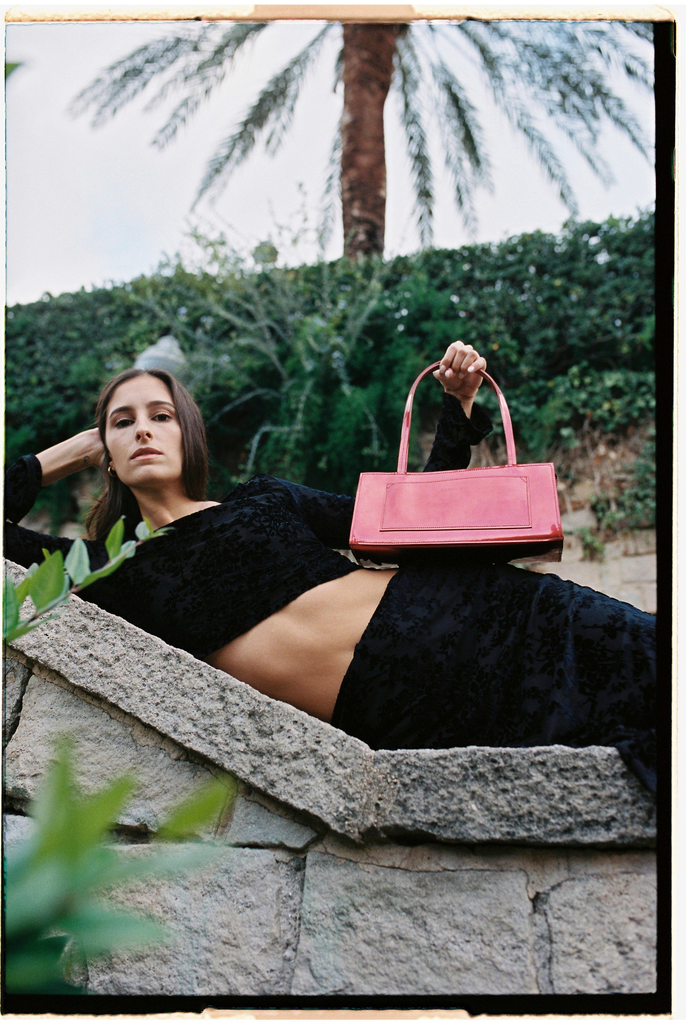 A model holding a hotdog bag in an aesthetically background. 100% made from deadstock leather.