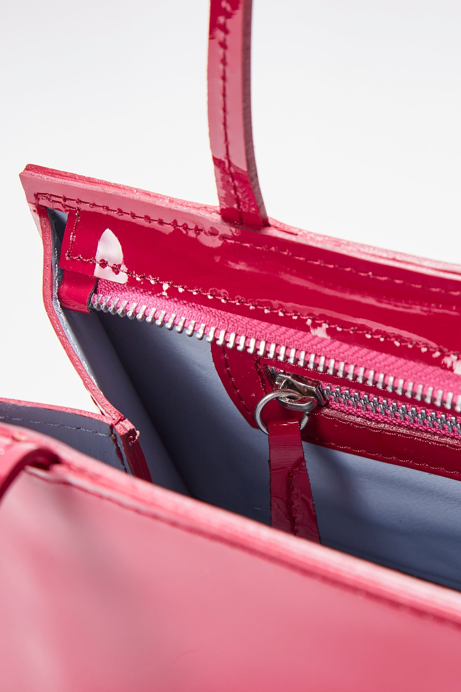 Close-up of the hotdog fuchsia bag in a white background. 100% made from deadstock leather.
