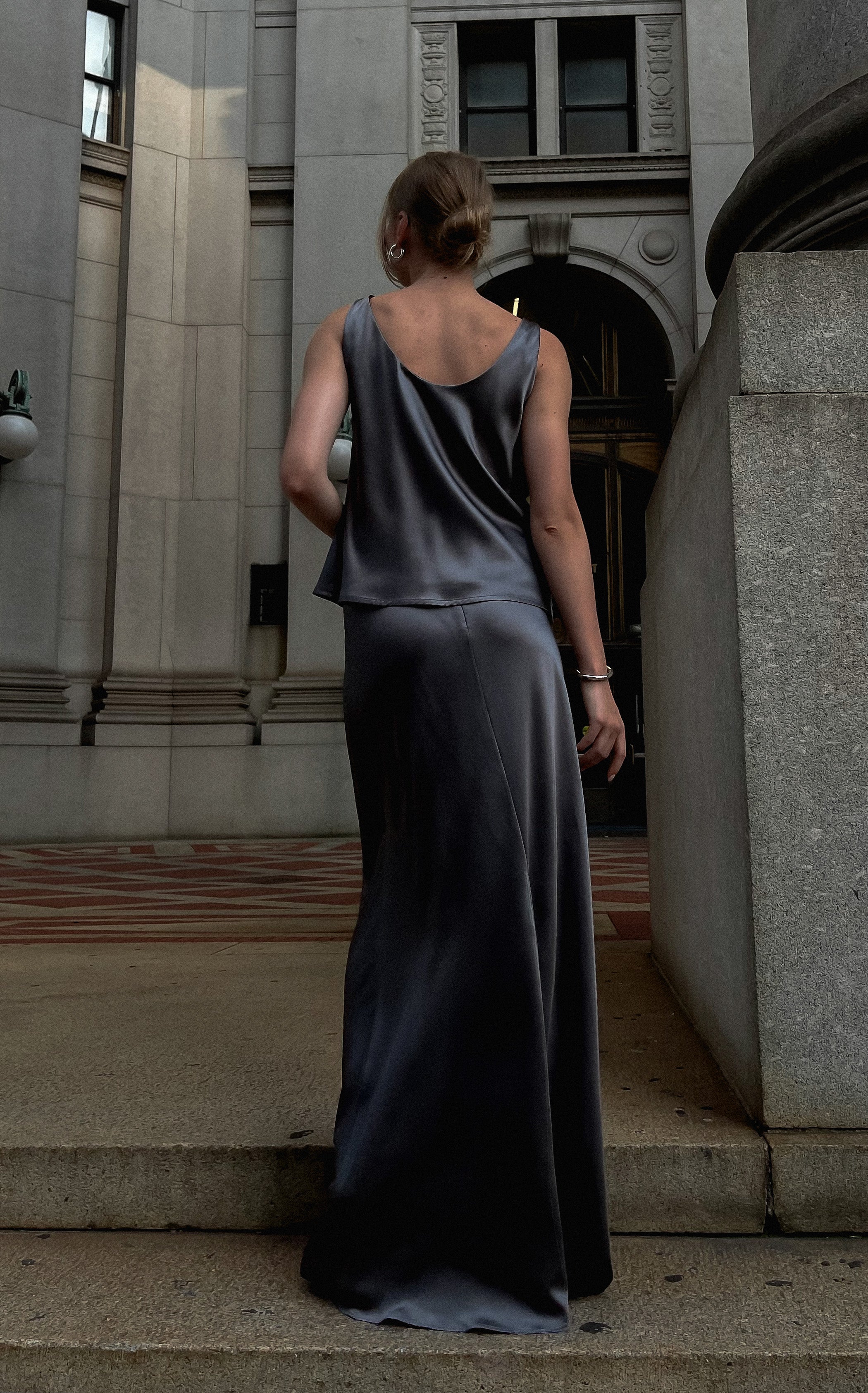 A model wearing the pearl grey siren skirt in an aesthetically background. 100% made from sustainable silk.