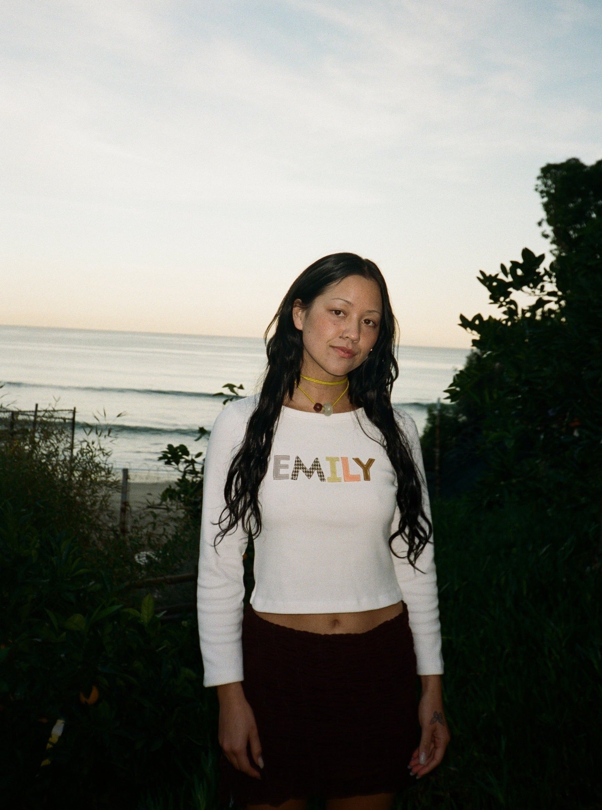 A model wearing the custom long sleeve in a outdoor background. Made from certified organic cotton and deadstock.