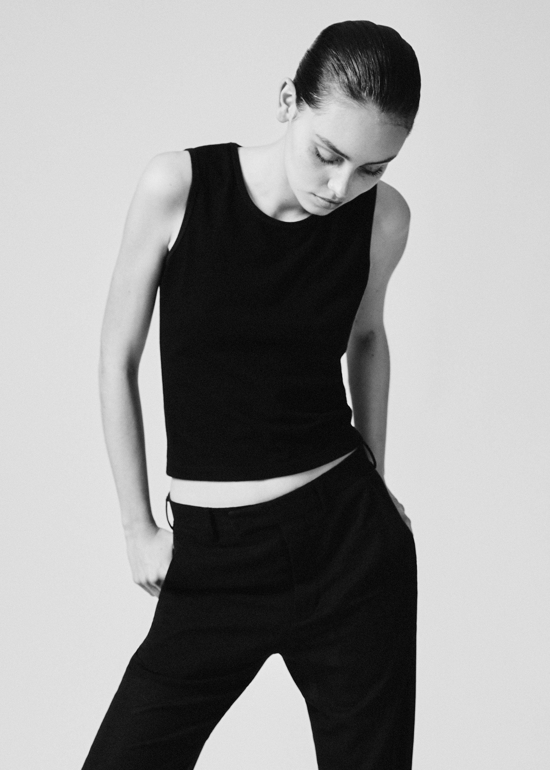 A model wearing the black 03 tank in a white background. 100% made from organic grown cotton.