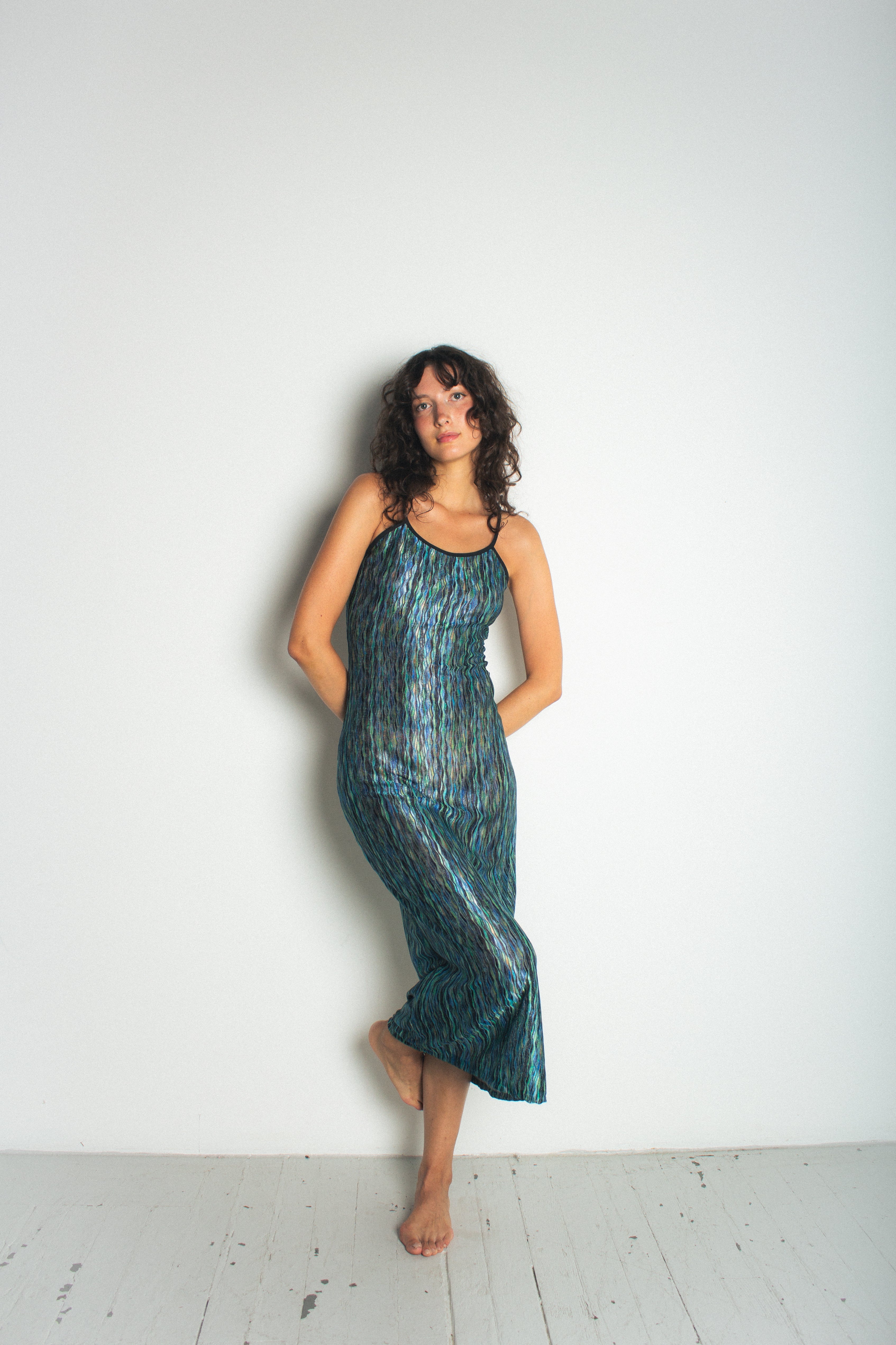 A model wearing the green naomi dress in a white background. 100% deadstock Missoni-like, polyester knit blend