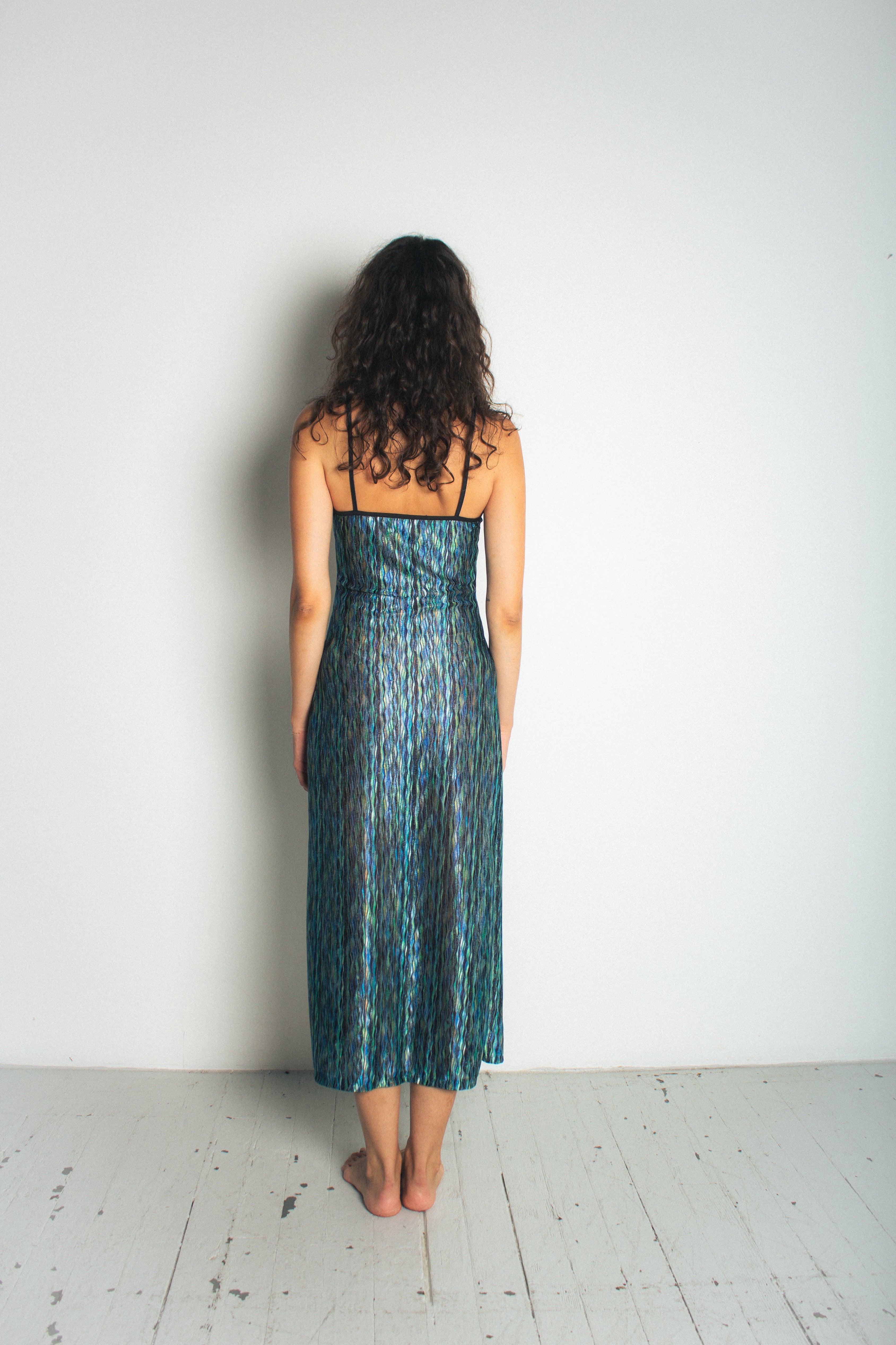 A model wearing the green naomi dress in a white background. 100% deadstock Missoni-like, polyester knit blend. BACK VIEW