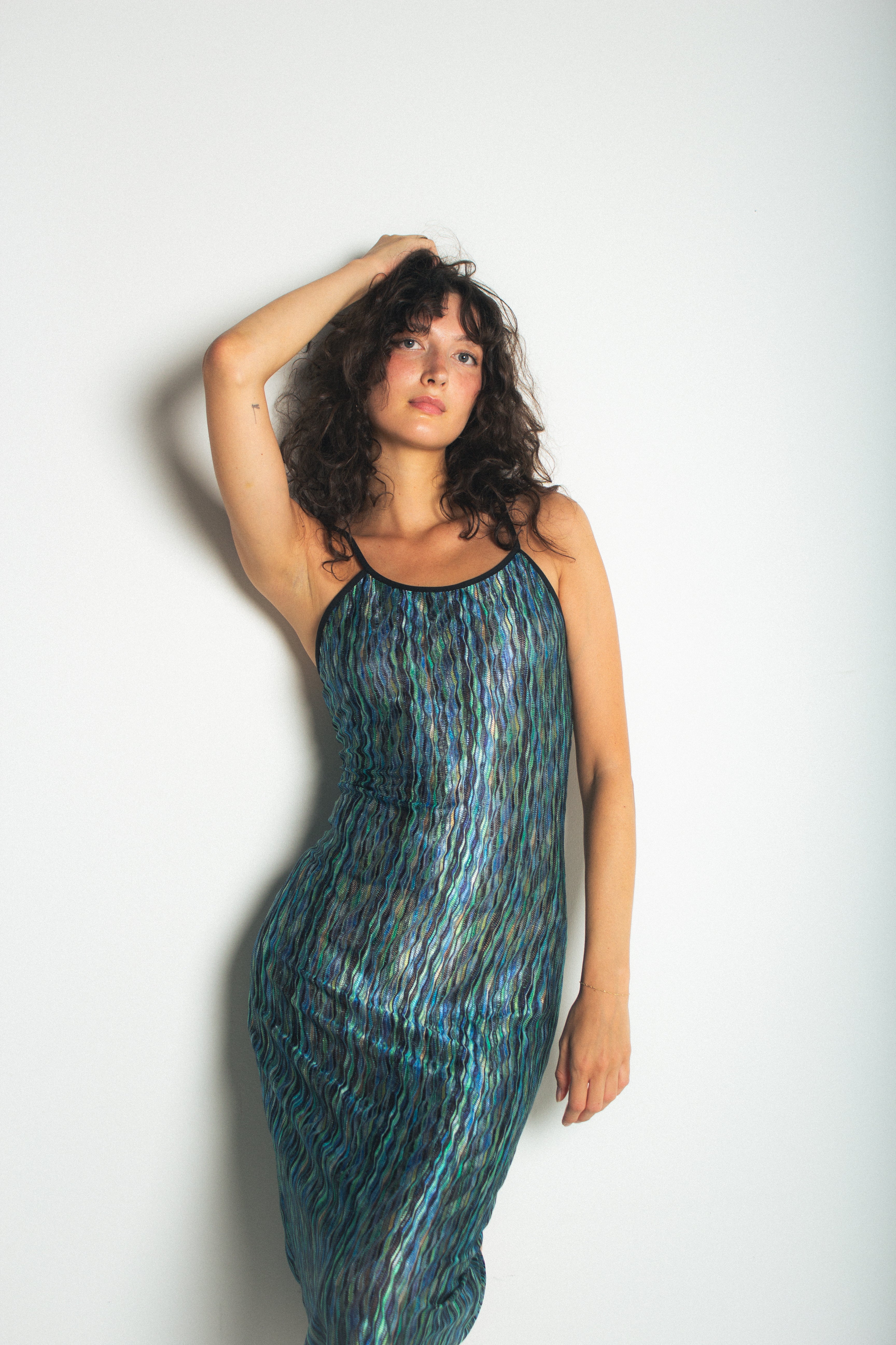 A model wearing the green naomi dress in a white background. 100% deadstock Missoni-like, polyester knit blend