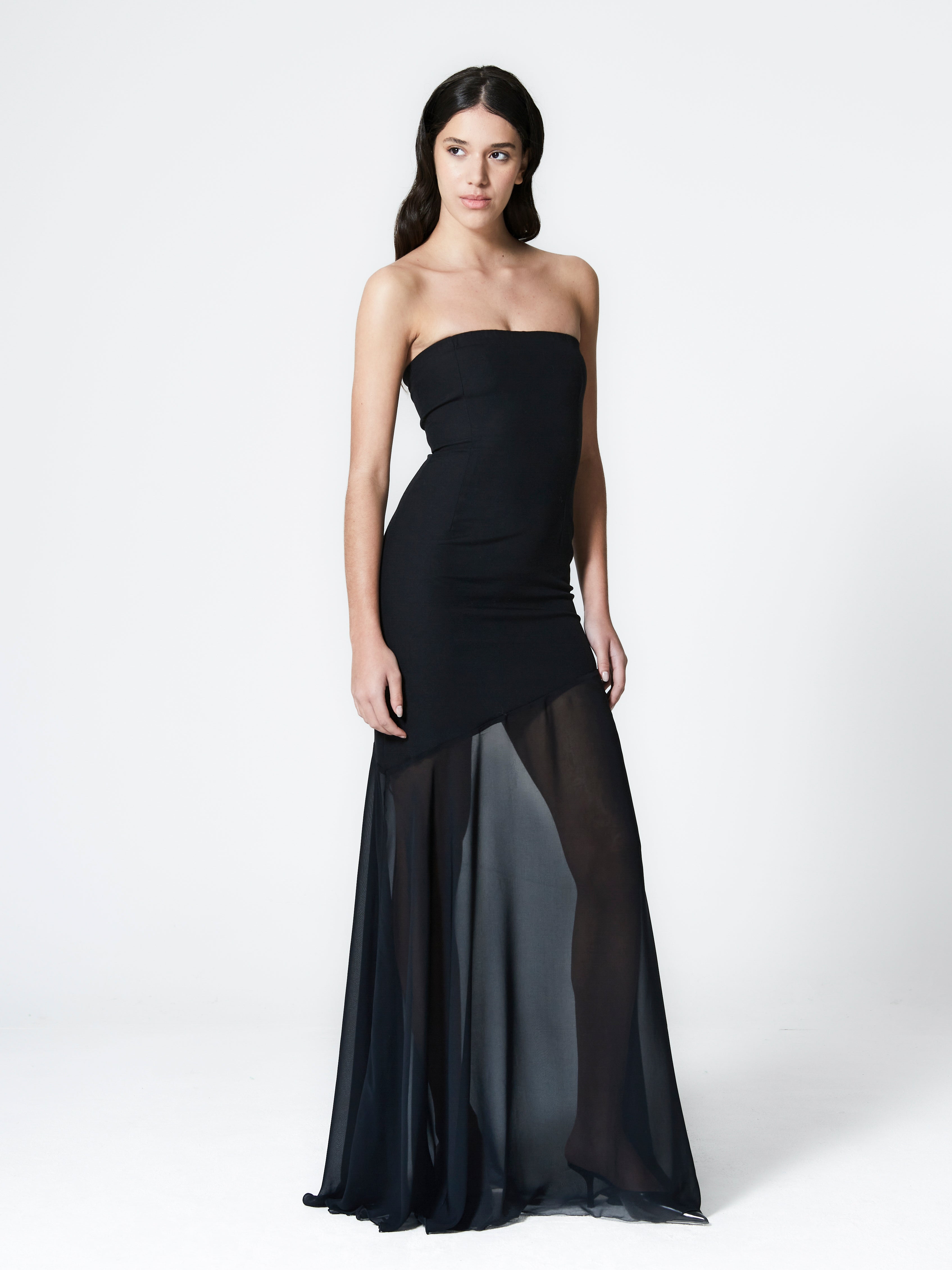 A model wearing the aria gown in a white background. Made from deadstock wool paired with deadstock soft sheer viscose chiffon