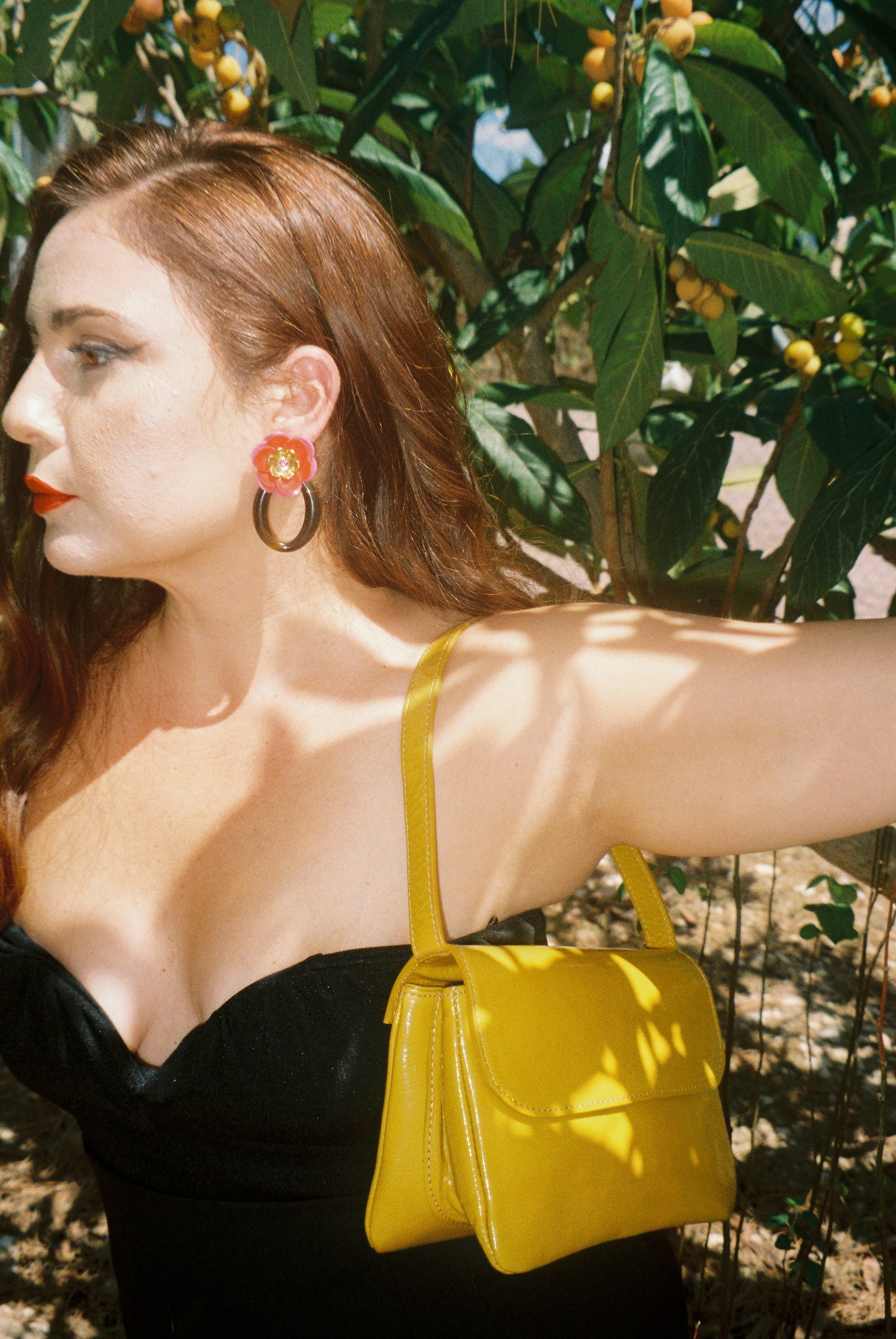 A model wearing the babe mustard bag in an aesthetically background. 100% made from deadstock leather. 