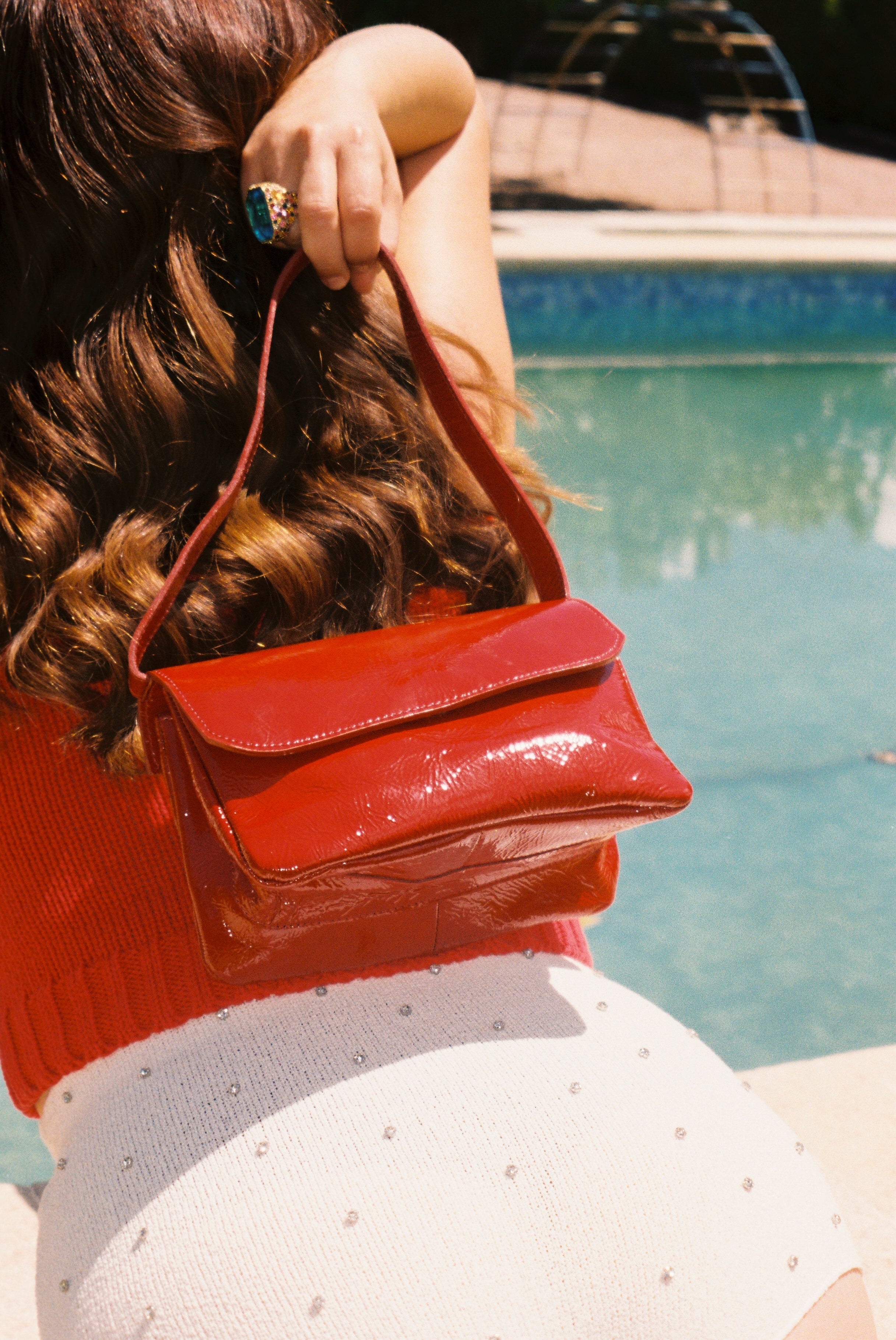 A model wearing the babe red bag in an aesthetically background. 100% made from deadstock leather. 