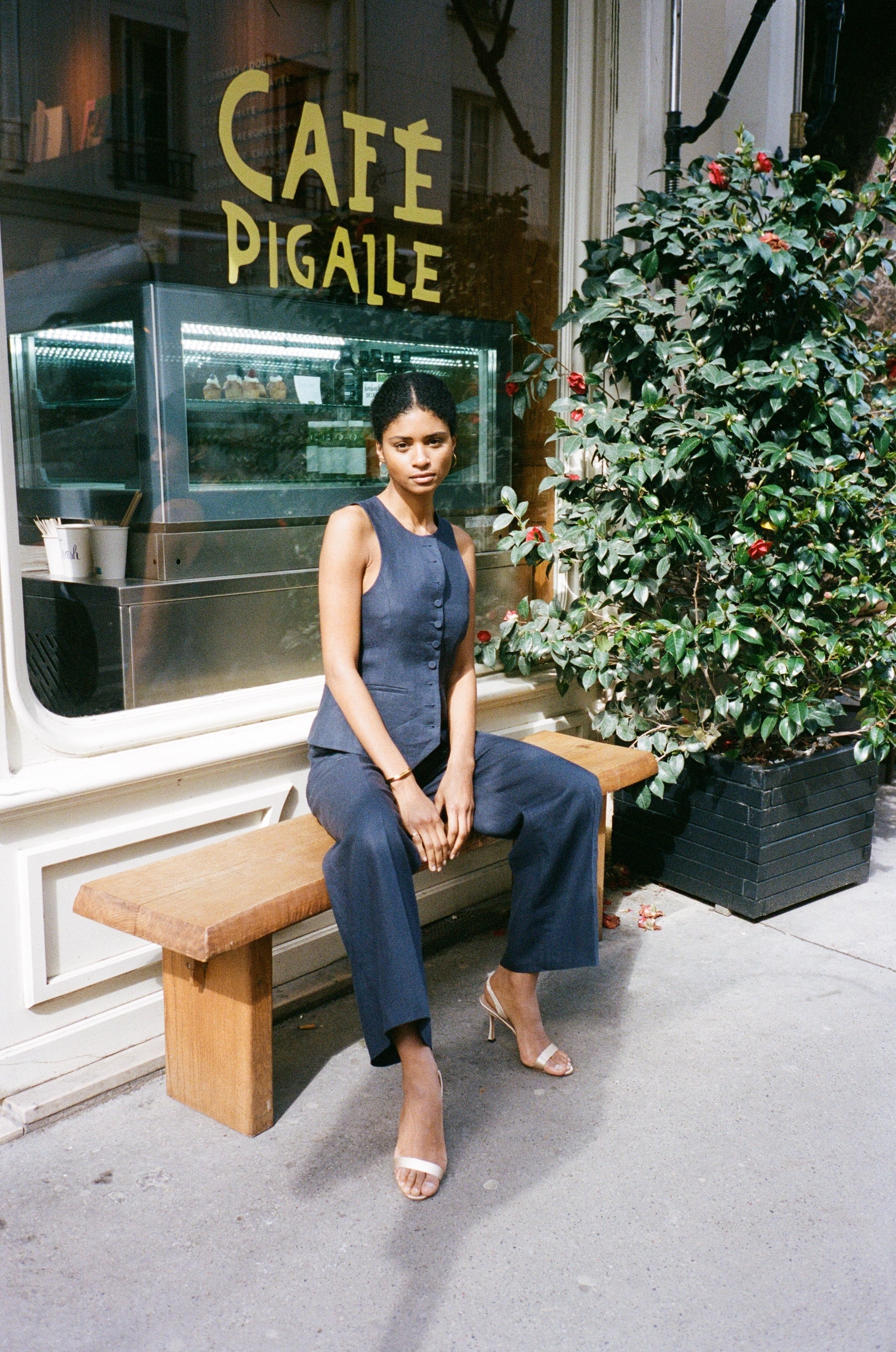 A model wearing the bianca navy blue pants in an aesthetically background. 100% upcycled GOTS certified linen.