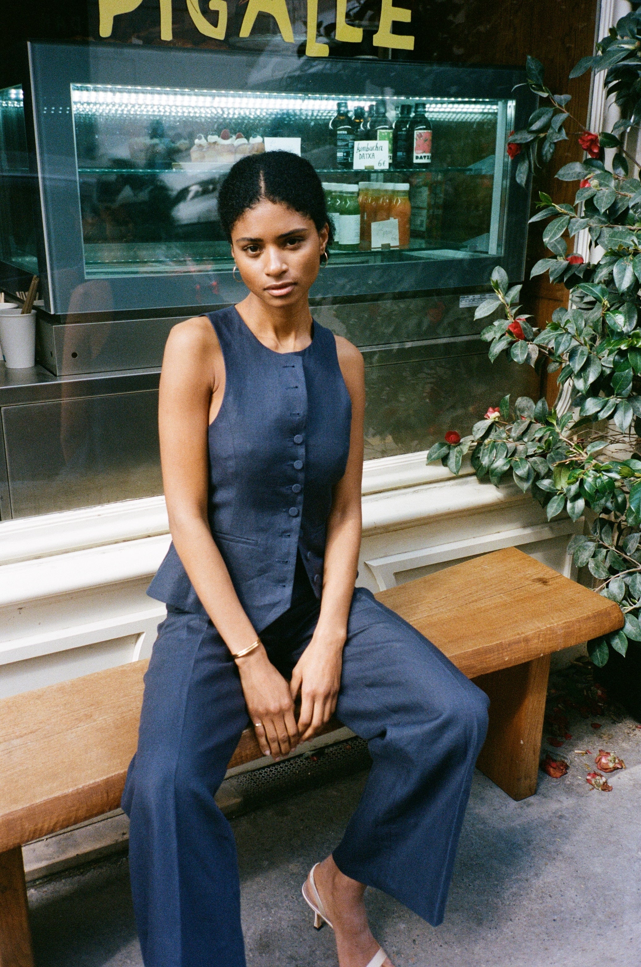 A model wearing the bianca navy blue pants in an aesthetically background. 100% upcycled GOTS certified linen.