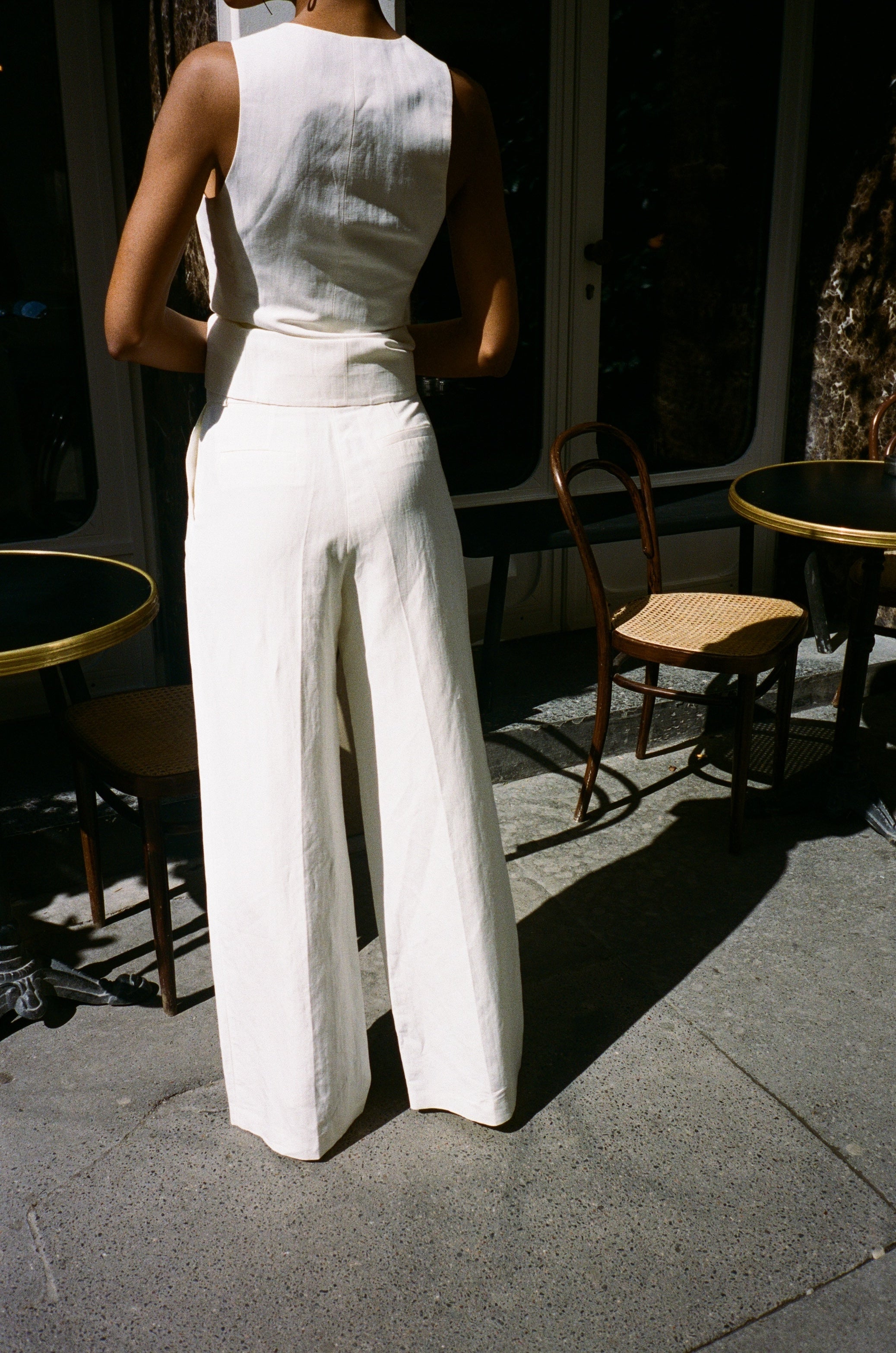 A model wearing the bianca off white pants in an aesthetically background. 100% upcycled linen and silk mix.