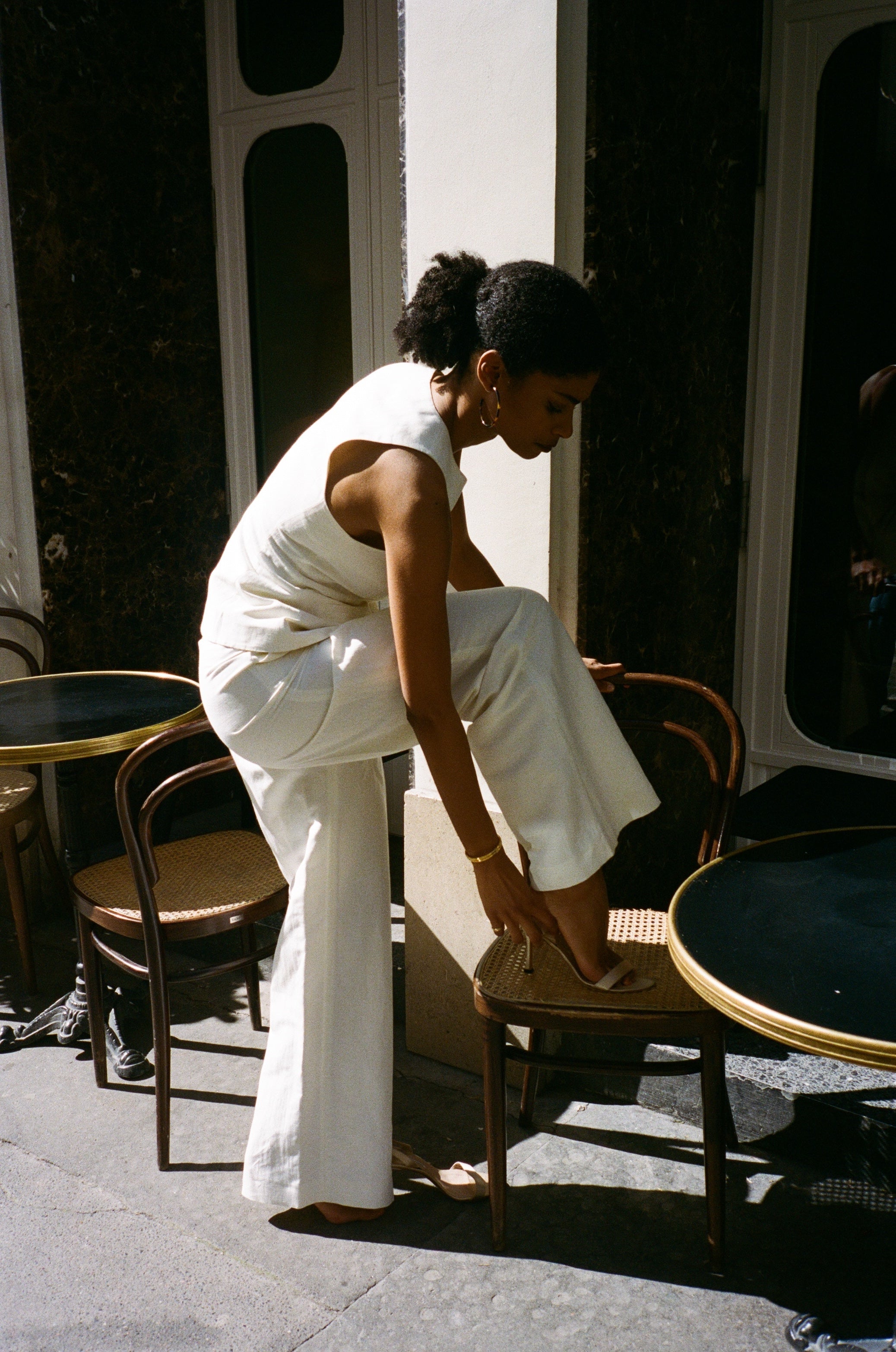 A model wearing the bianca off white pants in an aesthetically background. 100% upcycled linen and silk mix.