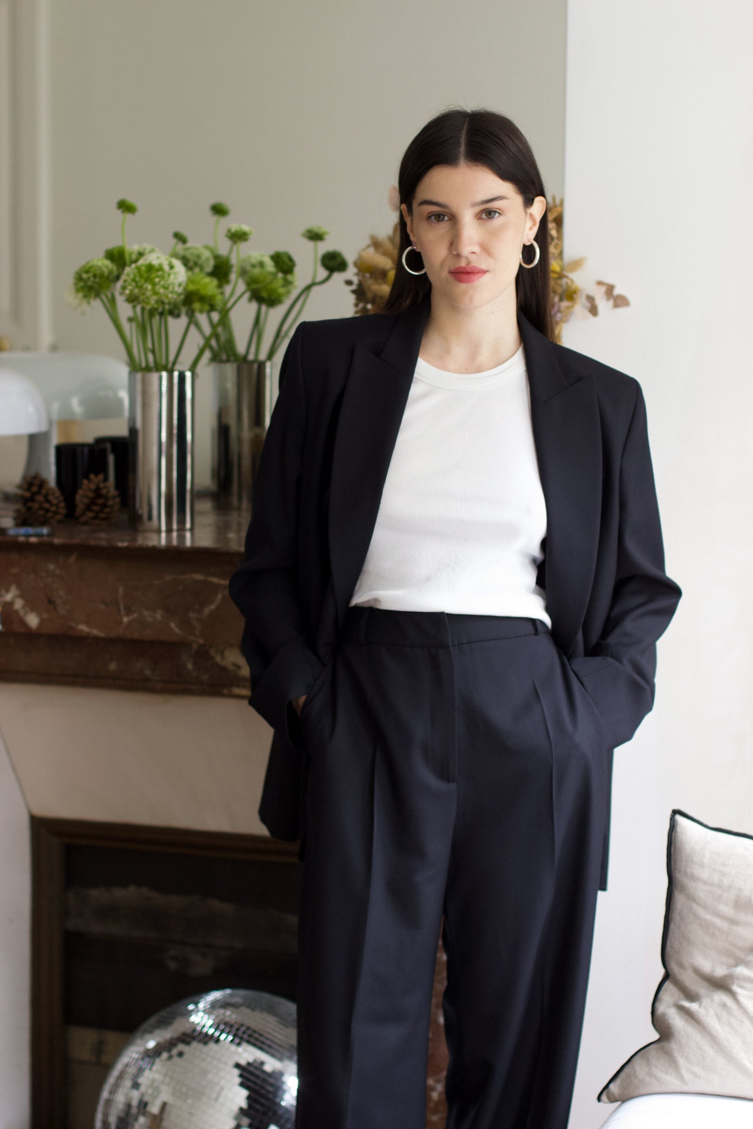 A model wearing the Christy Charcoal Wool Twill Jacket in an aesthetically background. 100% upcycled wool. 