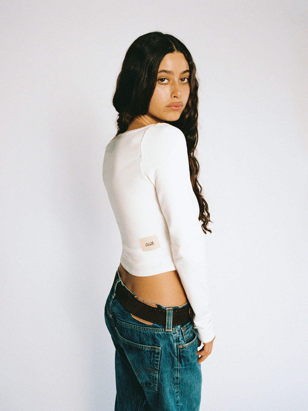 A model wearing the custom long sleeve in a white background. Made from certified organic cotton and deadstock.