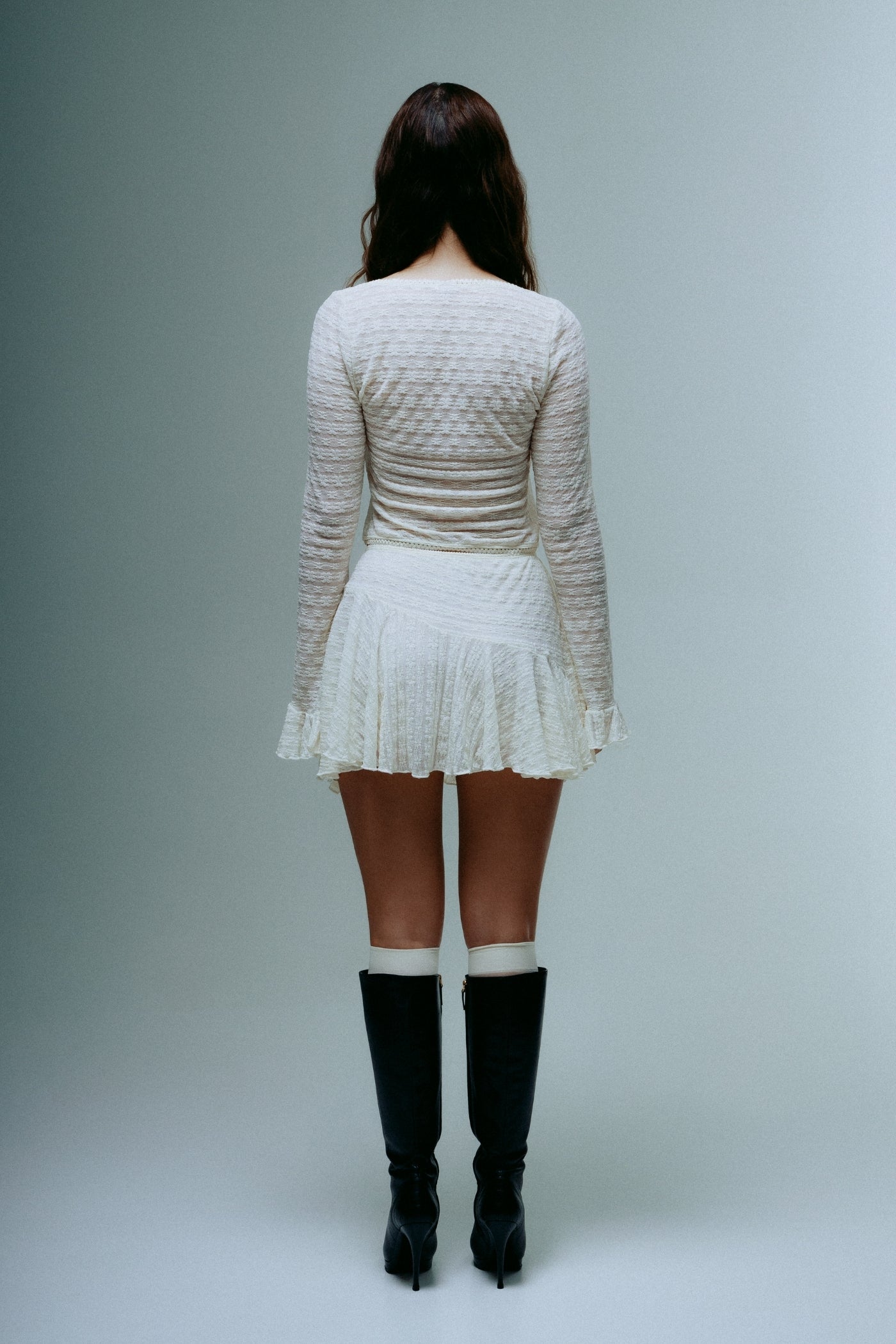A model wearing the dreamwave mini skirt in a white background. 100% deadstock lace material. 
