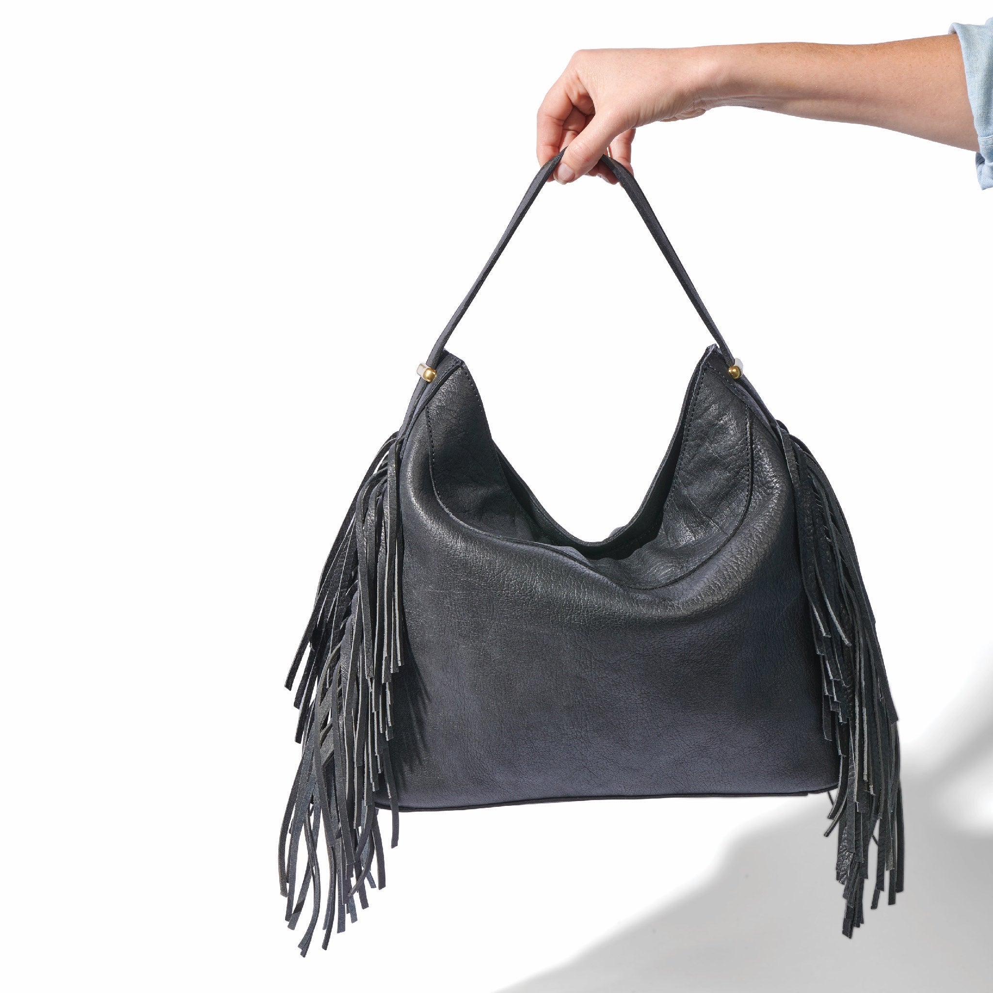 The fringe hobo in a white background. Leathers are sourced from regenerative ranches.