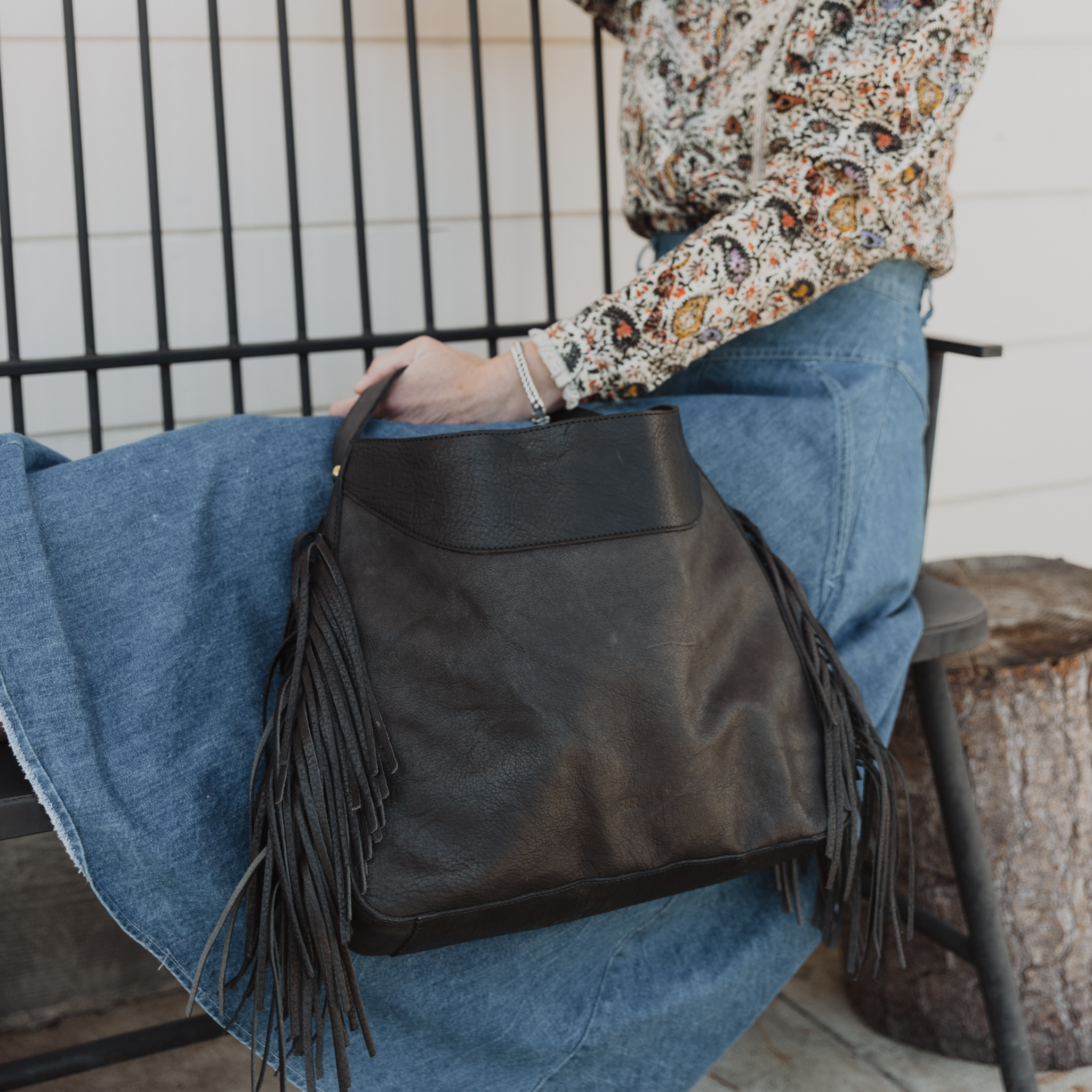 A model wearing the fringe hobo. Leathers are sourced from regenerative ranches.
