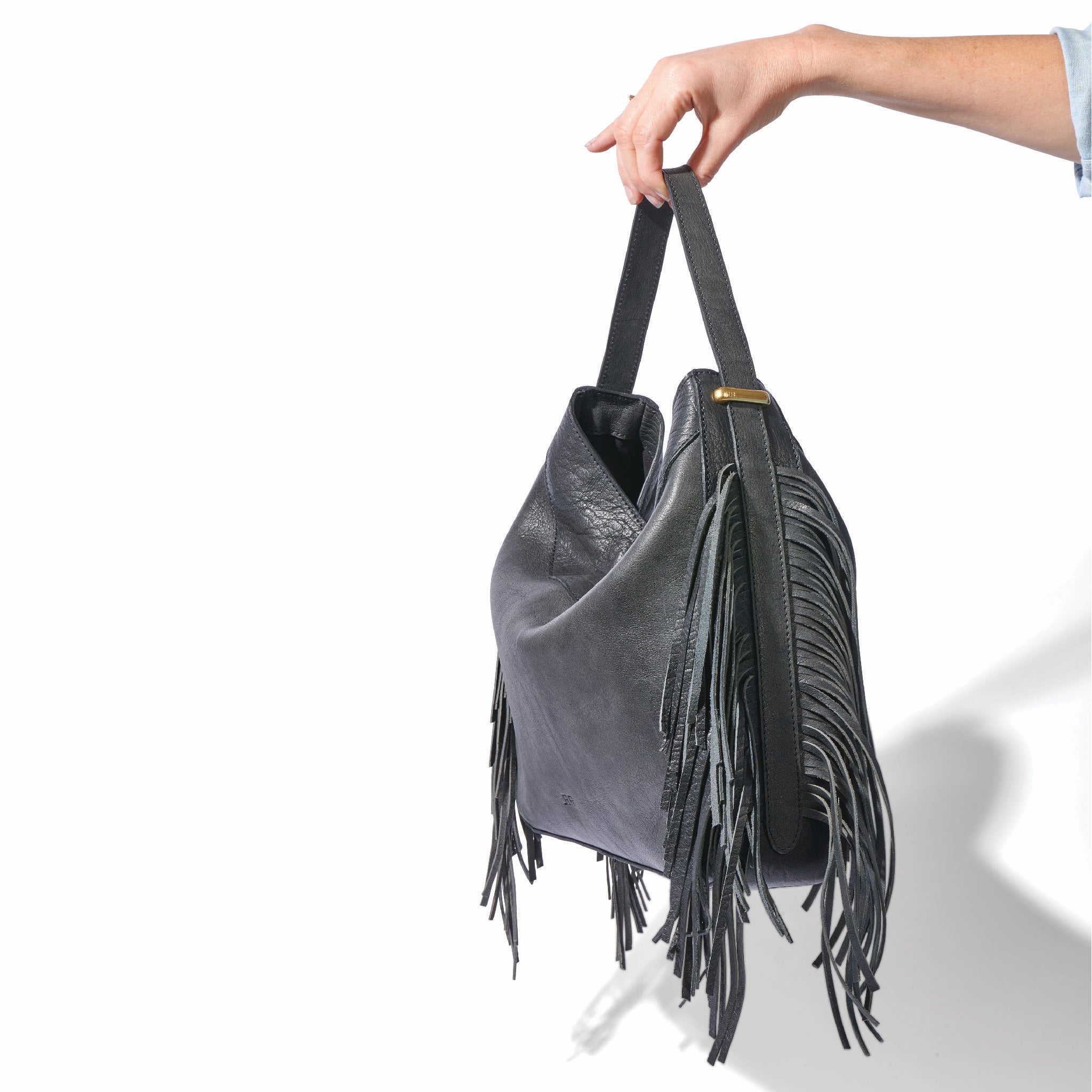 The fringe hobo in a white background. Leathers are sourced from regenerative ranches. SIDE VIEW