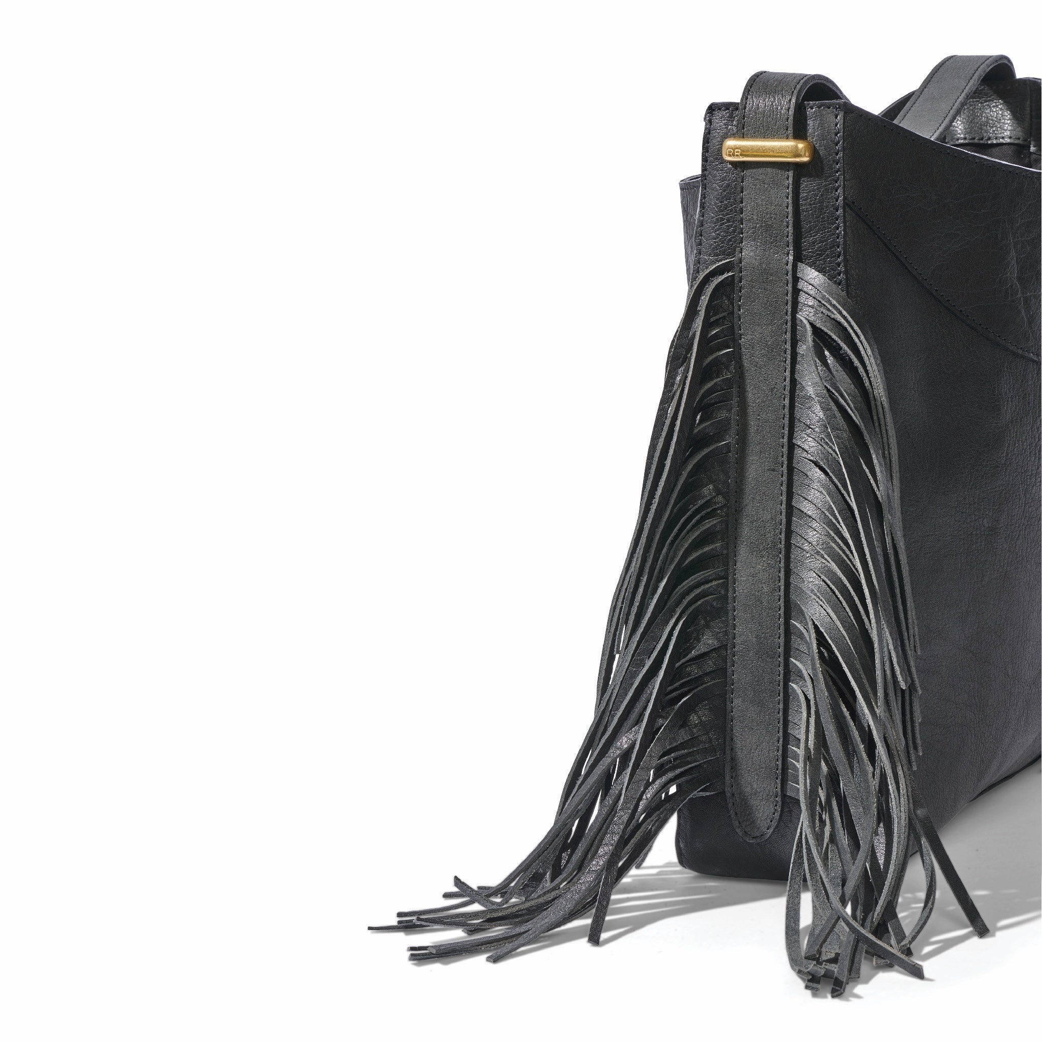 The fringe hobo in a white background. Leathers are sourced from regenerative ranches. CLOSE UP SIDE VIEW