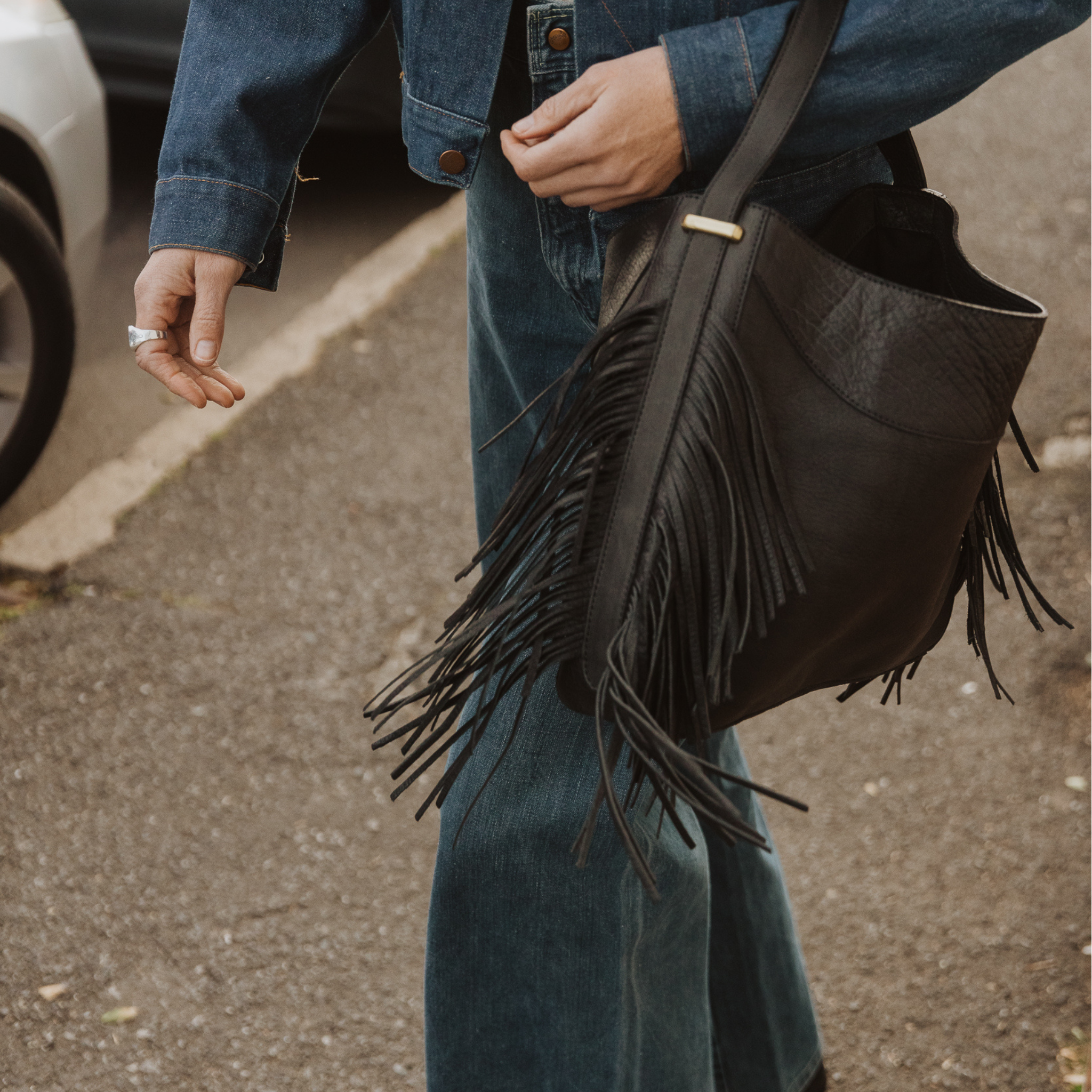 A model wearing the fringe hobo. Leathers are sourced from regenerative ranches.
