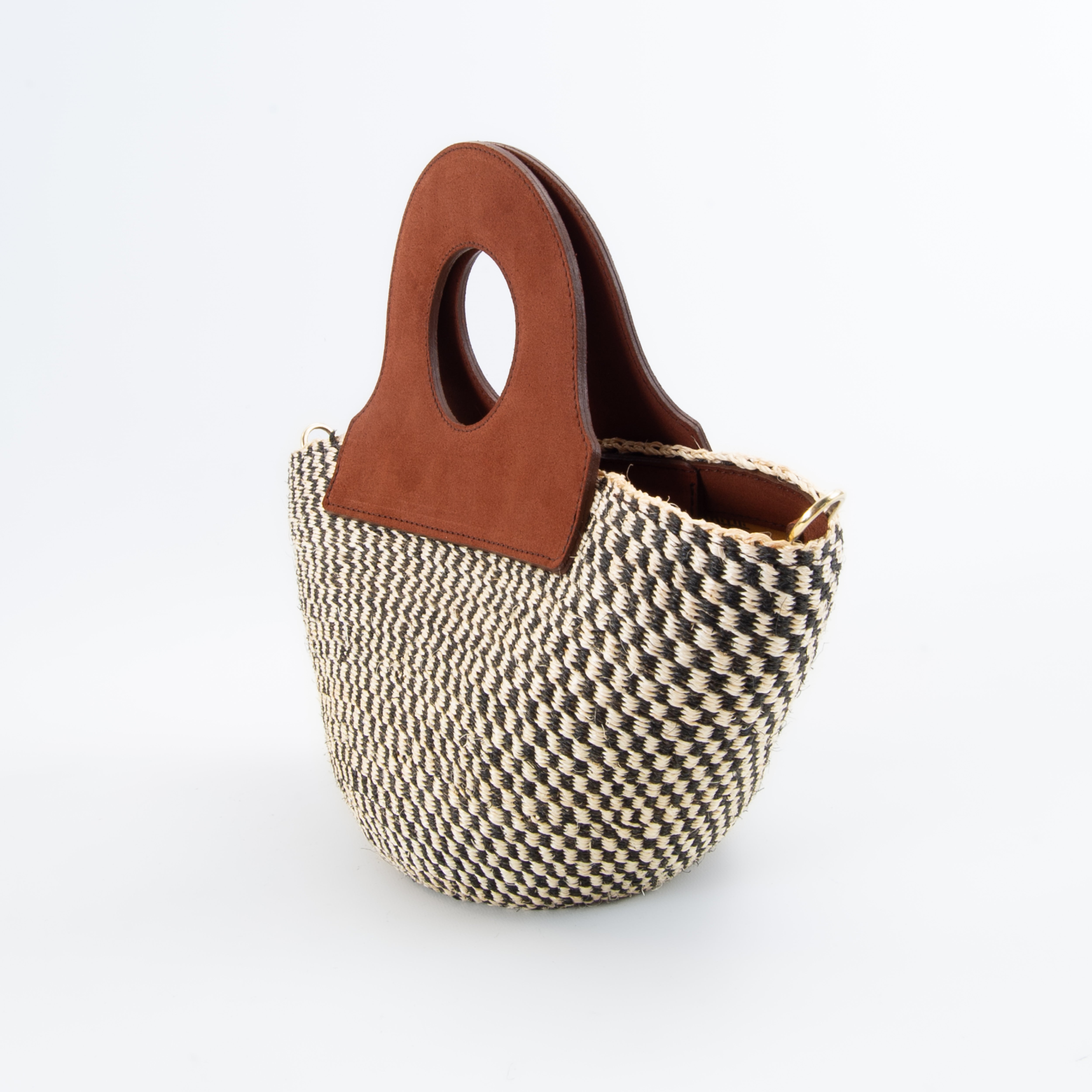 The handheld basket bag in a white background. Handwoven sisal basket made in Kenya. Finished in England using chrome-free leather. SIDE VIEW