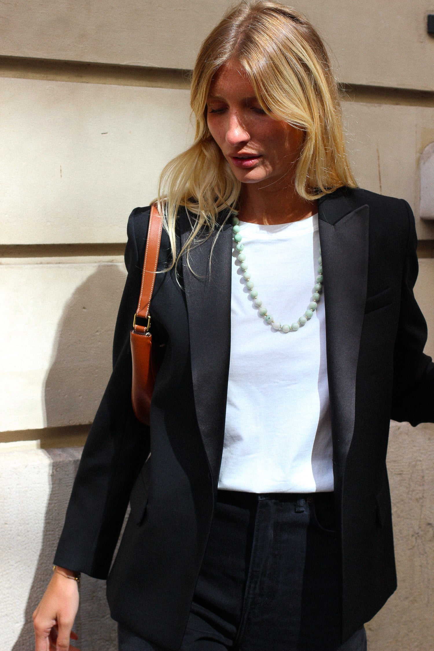 A model wearing the lauren black wool tuxedo blazer in an aesthetically outside background. 100% made from sustainable wool. 