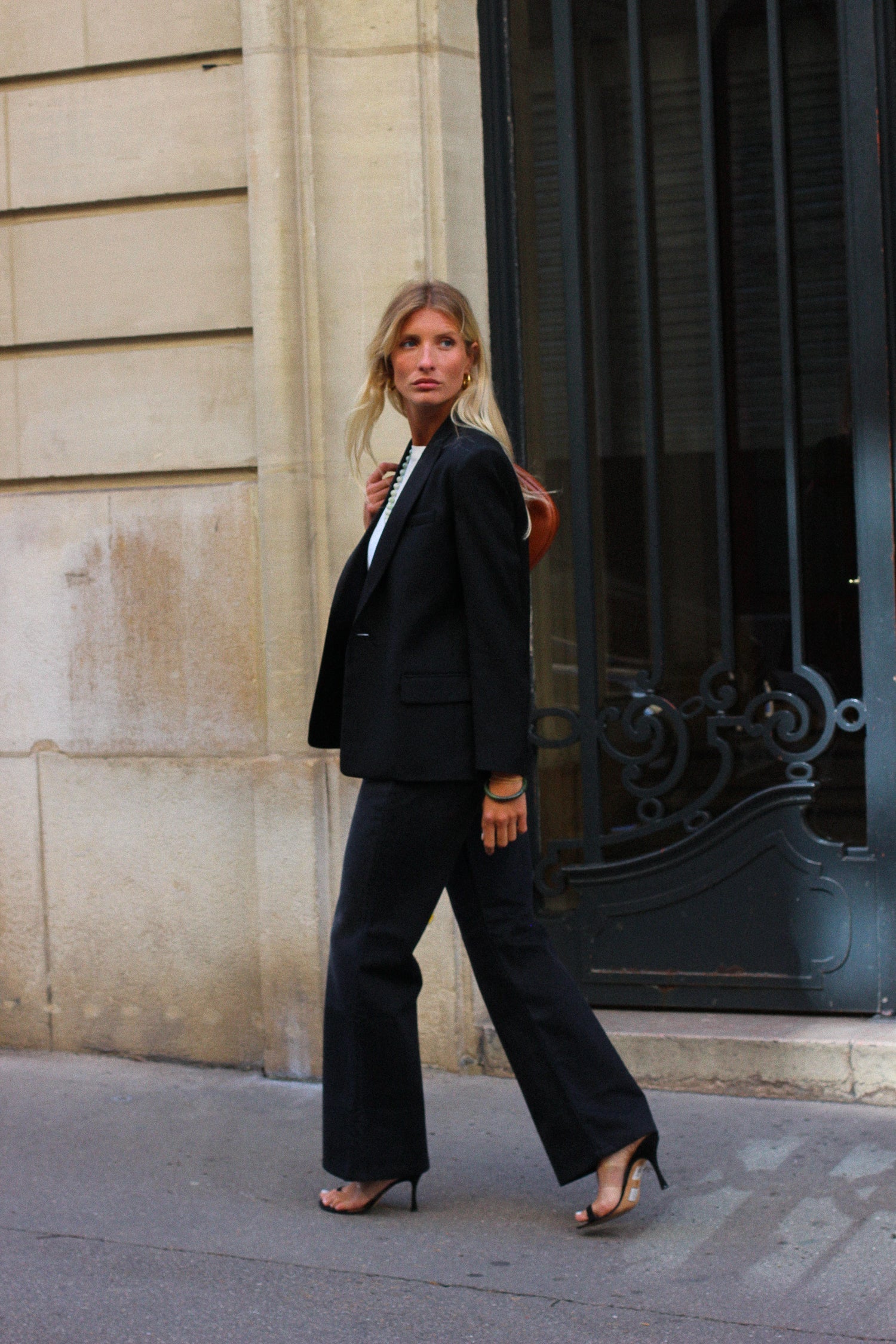 A model wearing the lauren black wool tuxedo blazer in an aesthetically outside background. 100% made from sustainable wool. 