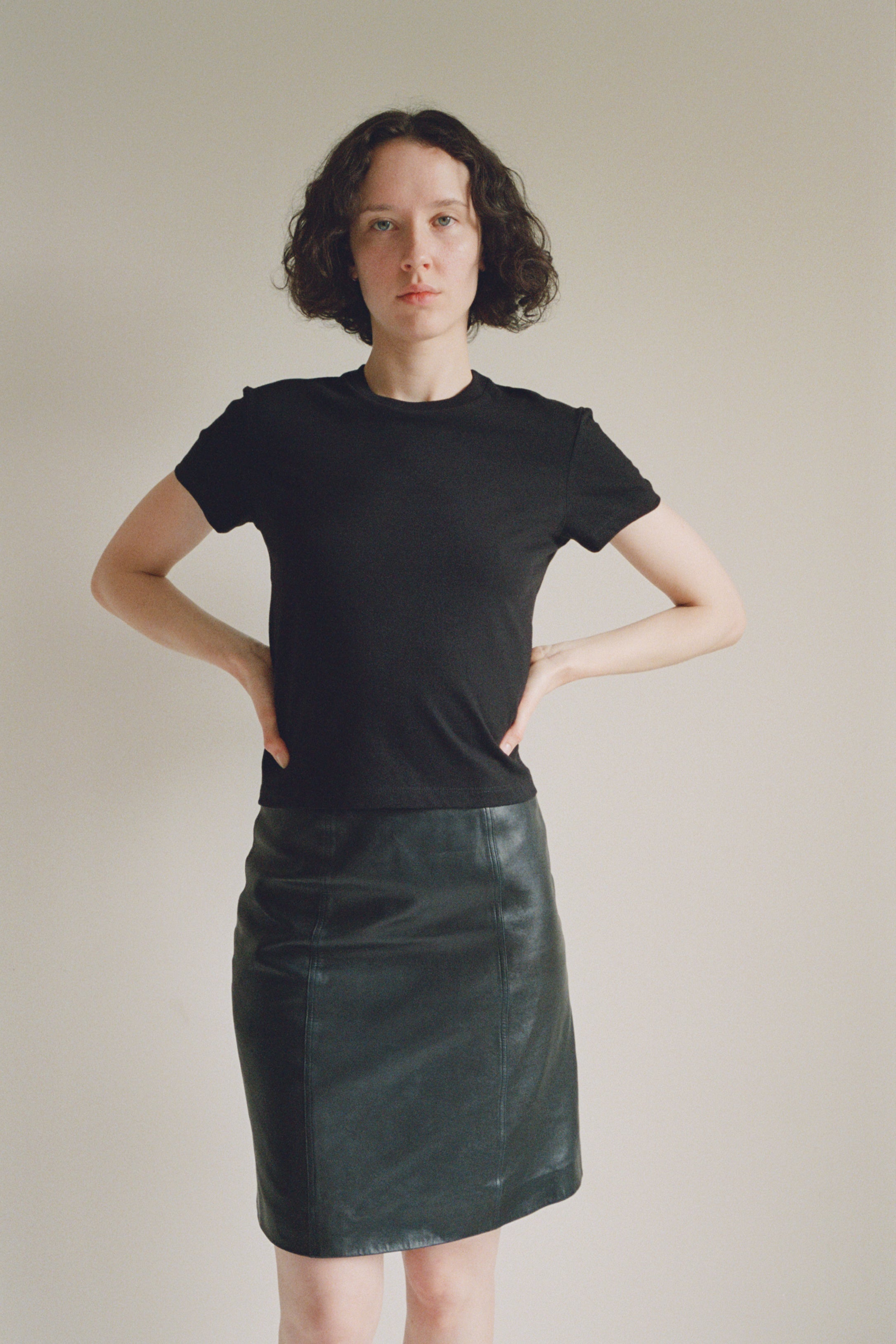 A model wearing the black little tshirt in a white background. 100% made from organic grown cotton. 