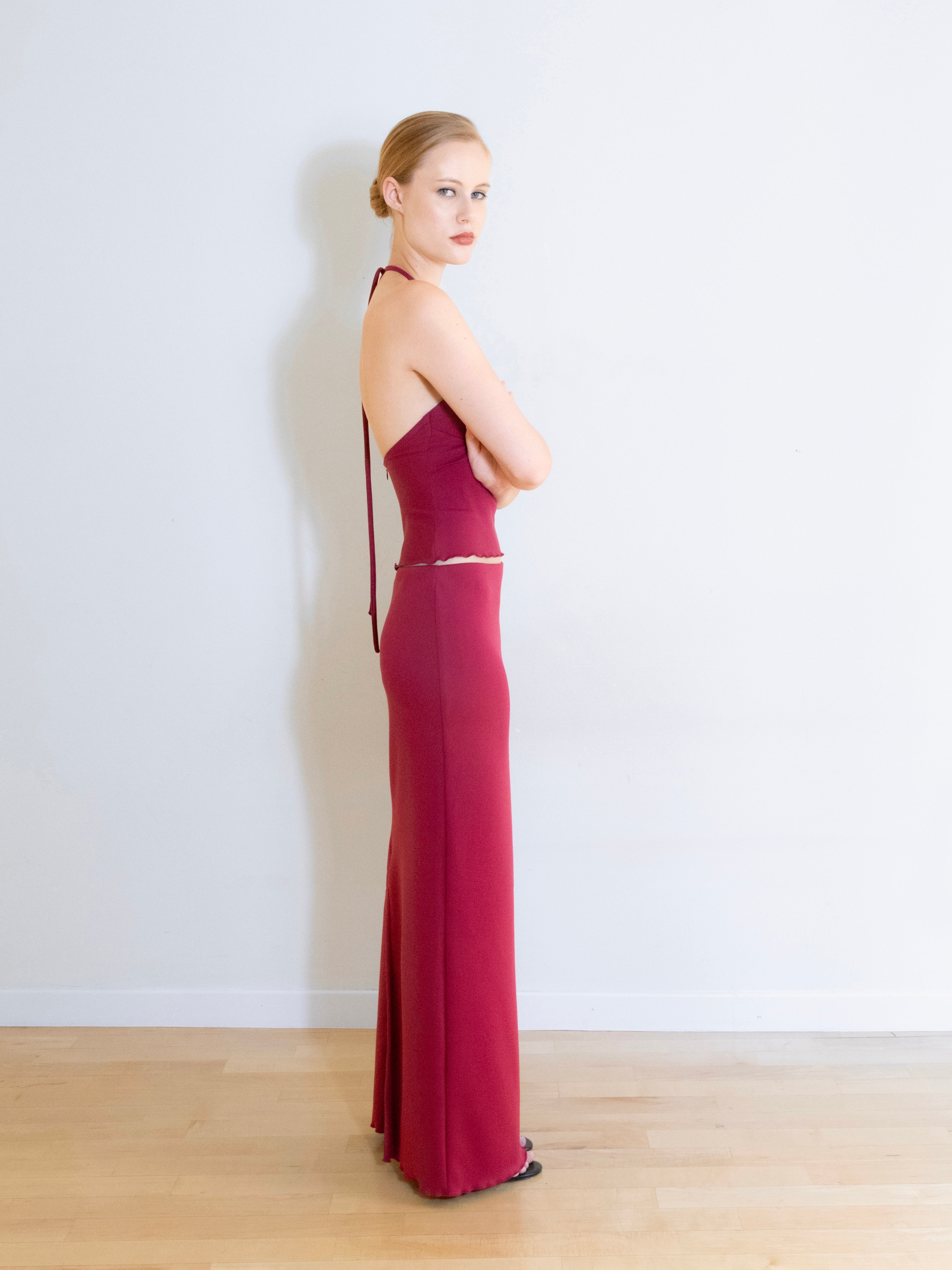 A model wearing the Luna knit maxi skirt in a white background. Made from soft, stretchy deadstock fabric