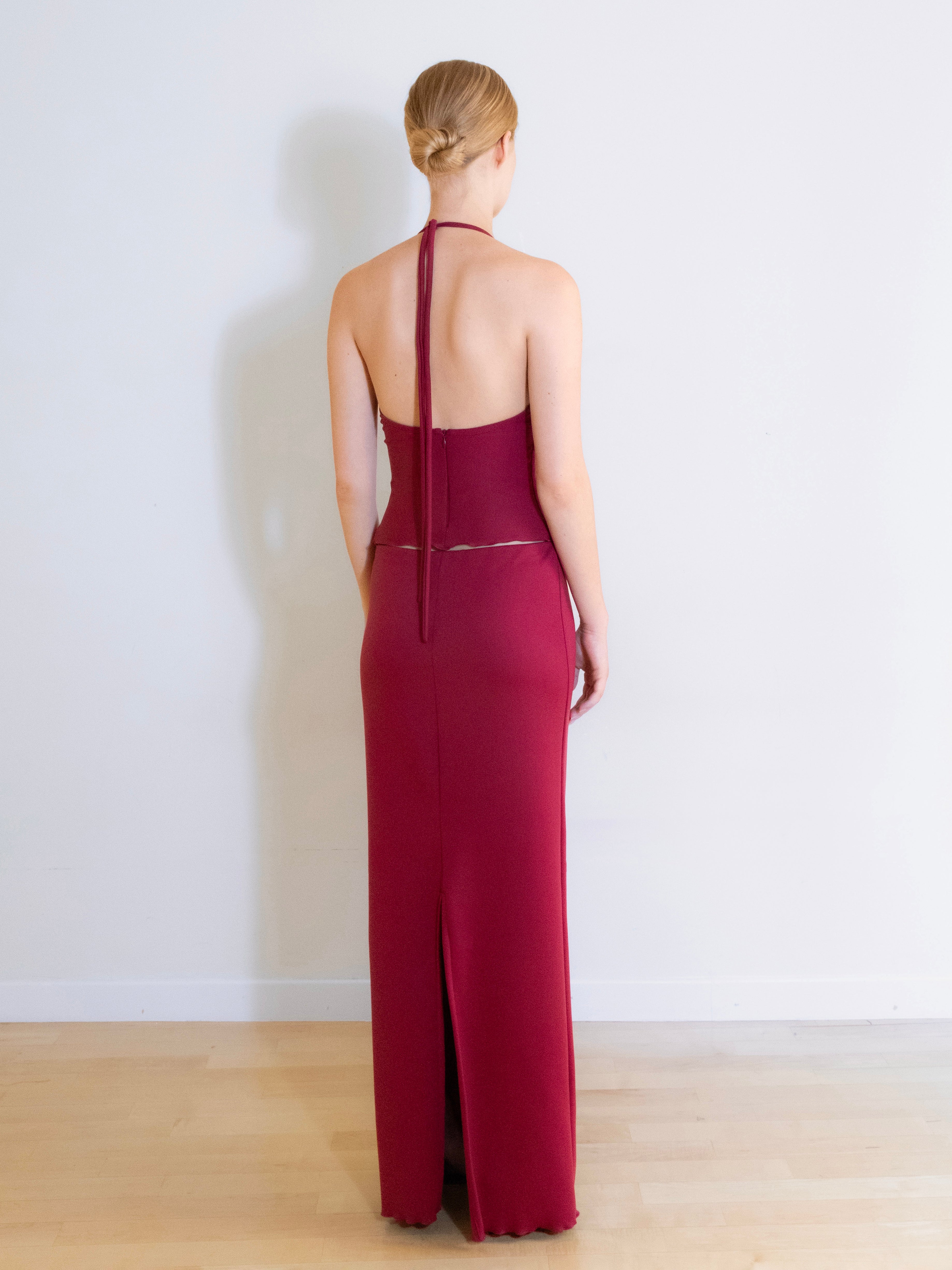 A model wearing the Luna knit maxi skirt in a white background. Made from soft, stretchy deadstock fabric