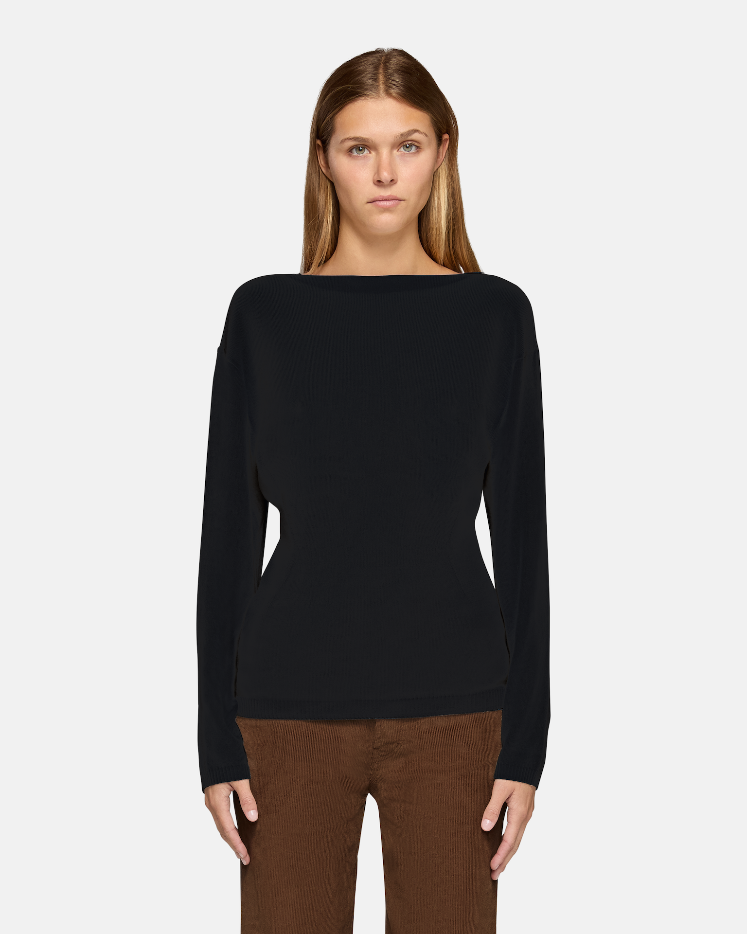 A model wearing the millie boat neck sweater in black in a white background. 100% made from cotton.