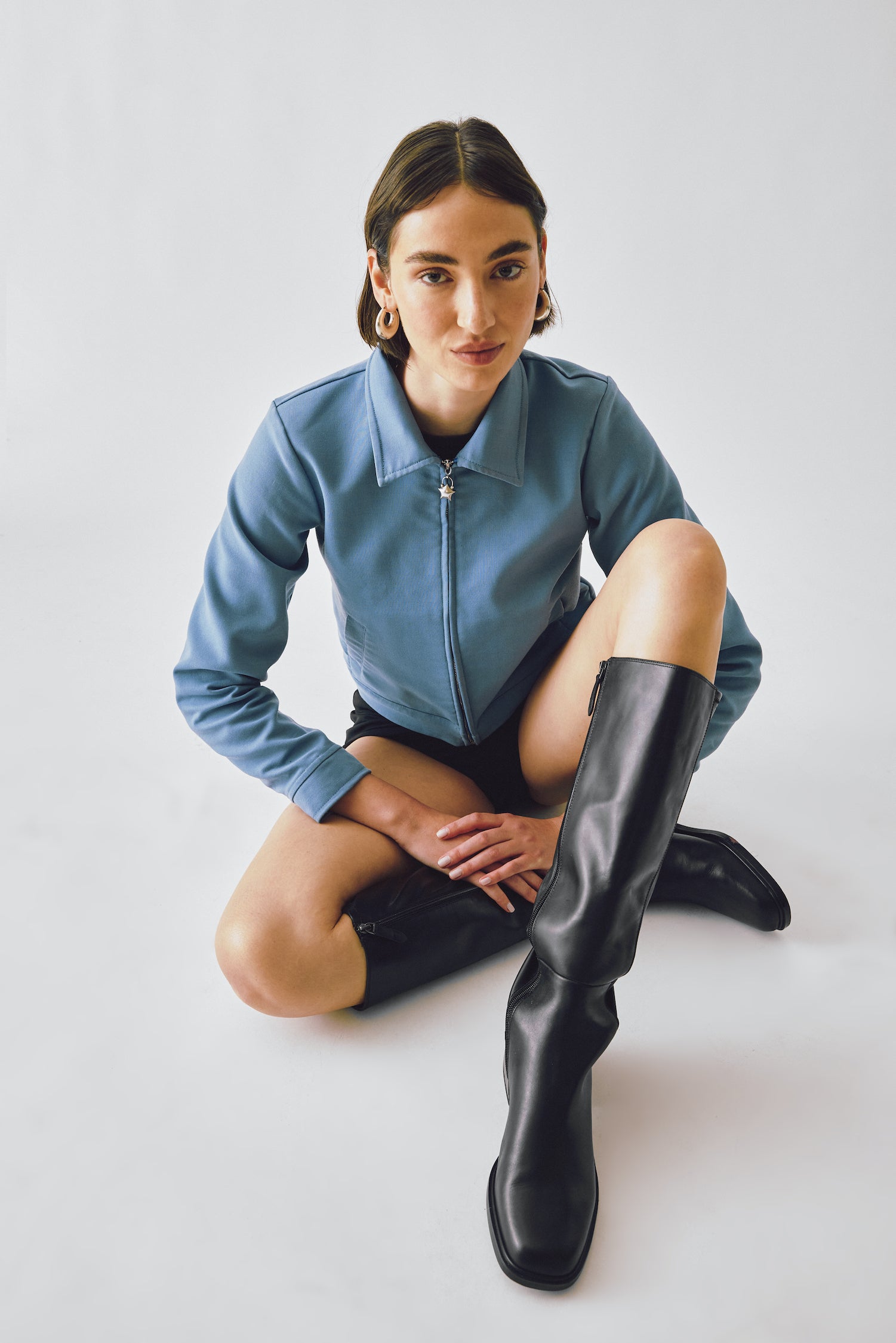 A model wearing the Miro Jacket in a white background. Deadstock wool blend with a recycled satin lining.