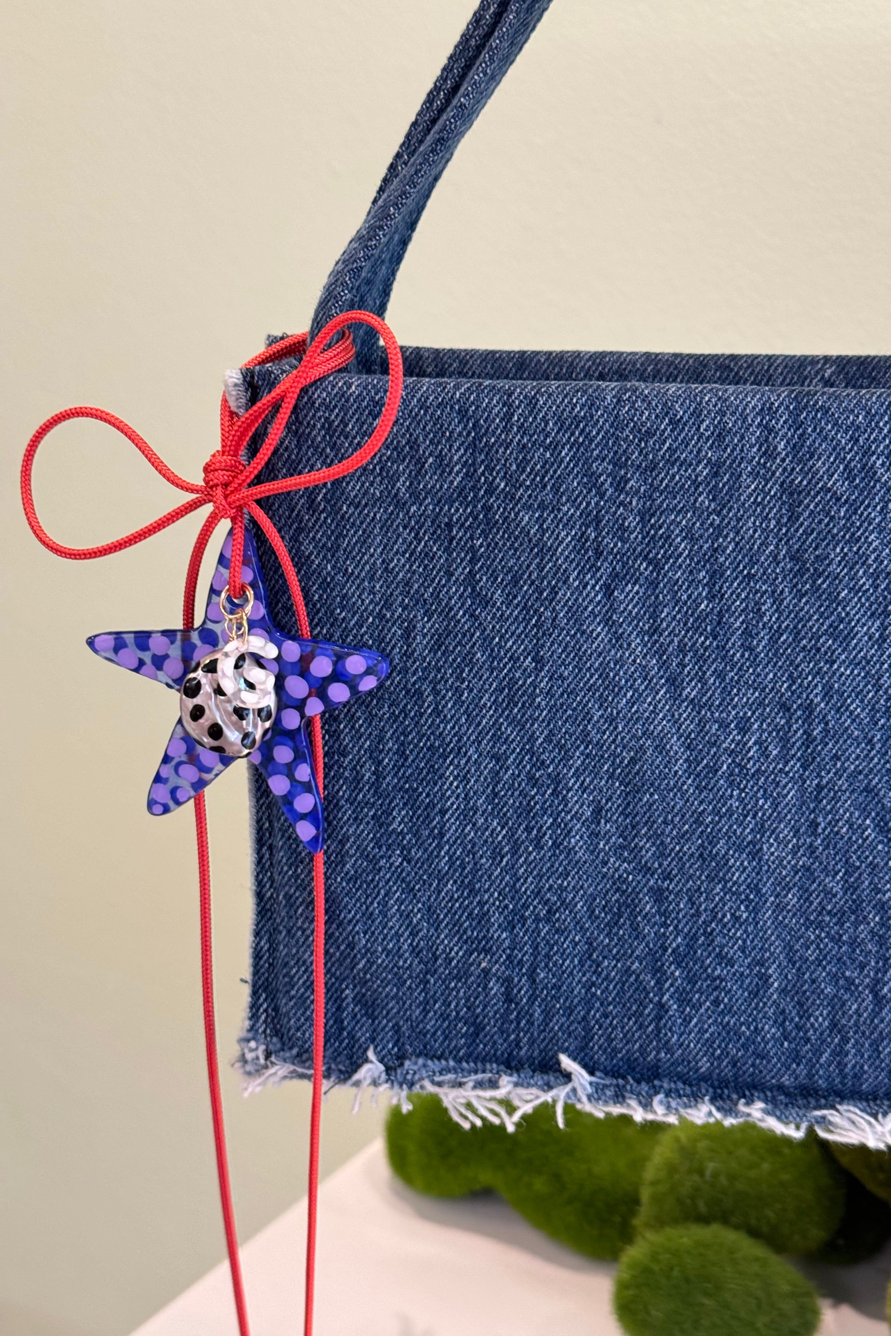 The plum star charm in an aesthetically background. Charm are 3D printed and hand finished. Made in New York. CLOSE-UP