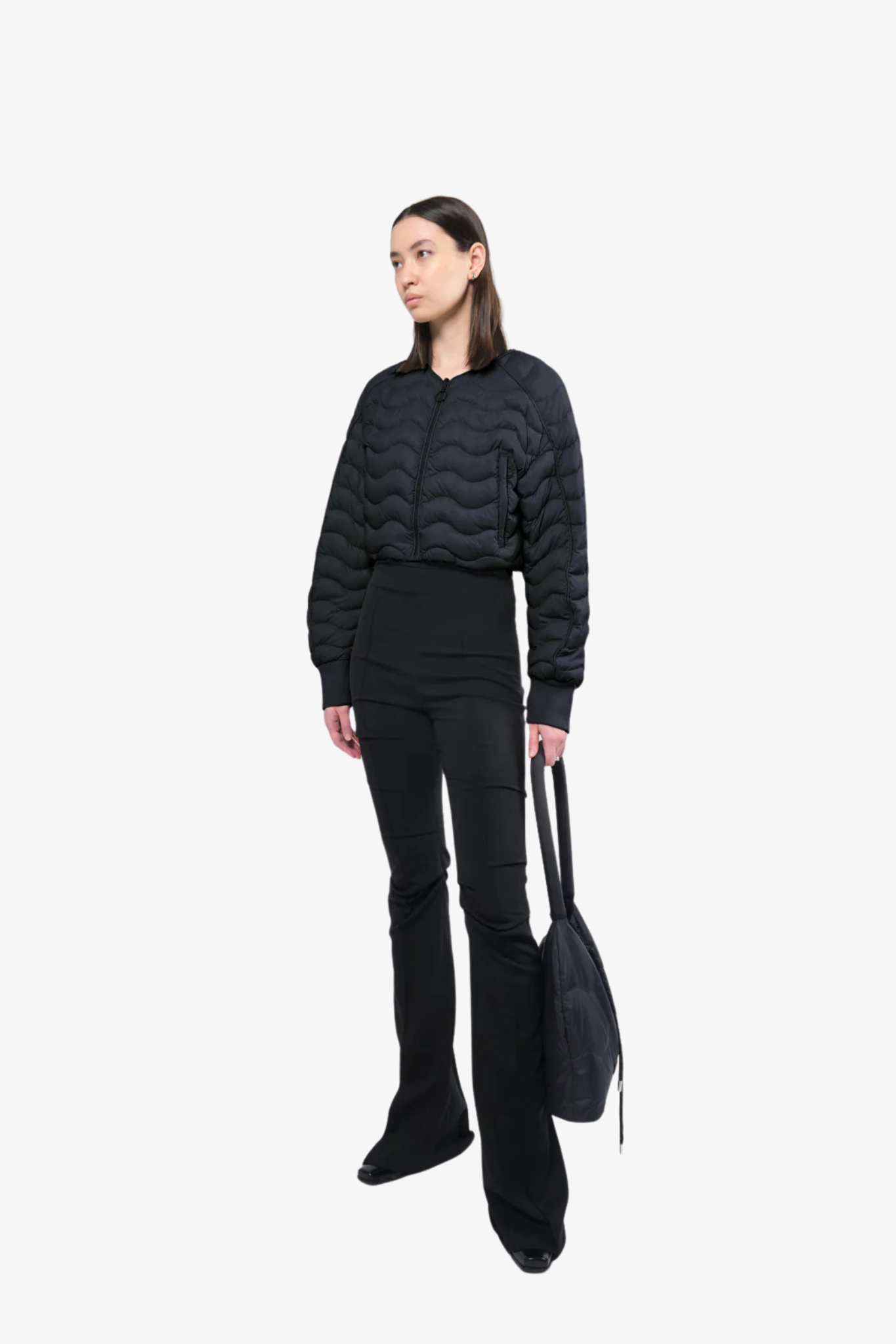 Model wearing a light crop puffer jacket in a white background. 100% made from recycled fabric. 