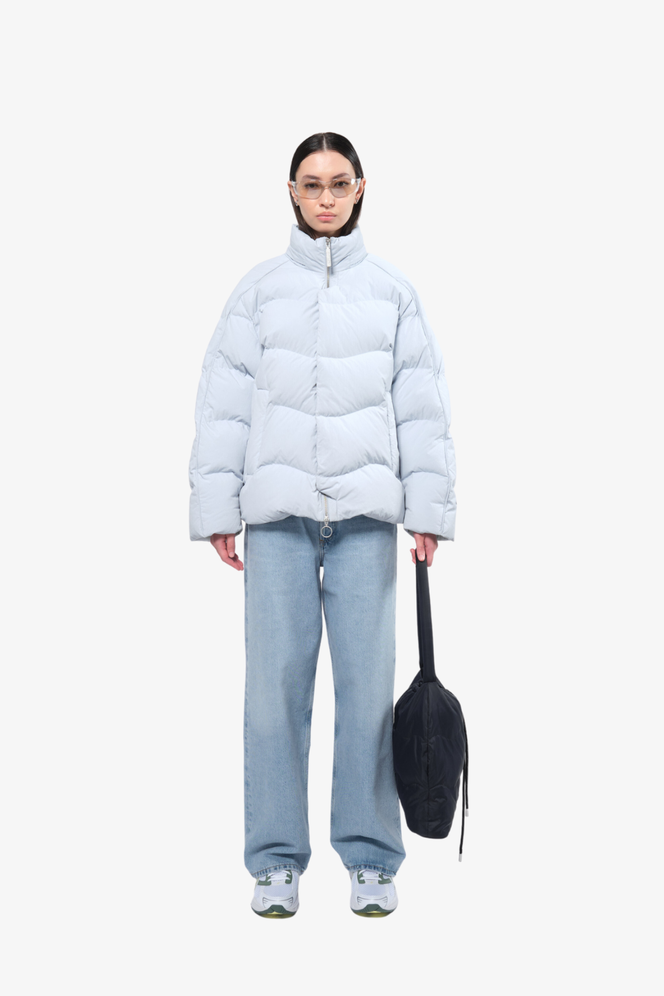 Model wearing a puffer jacket in a white background. 100% made from recycled fabric. 