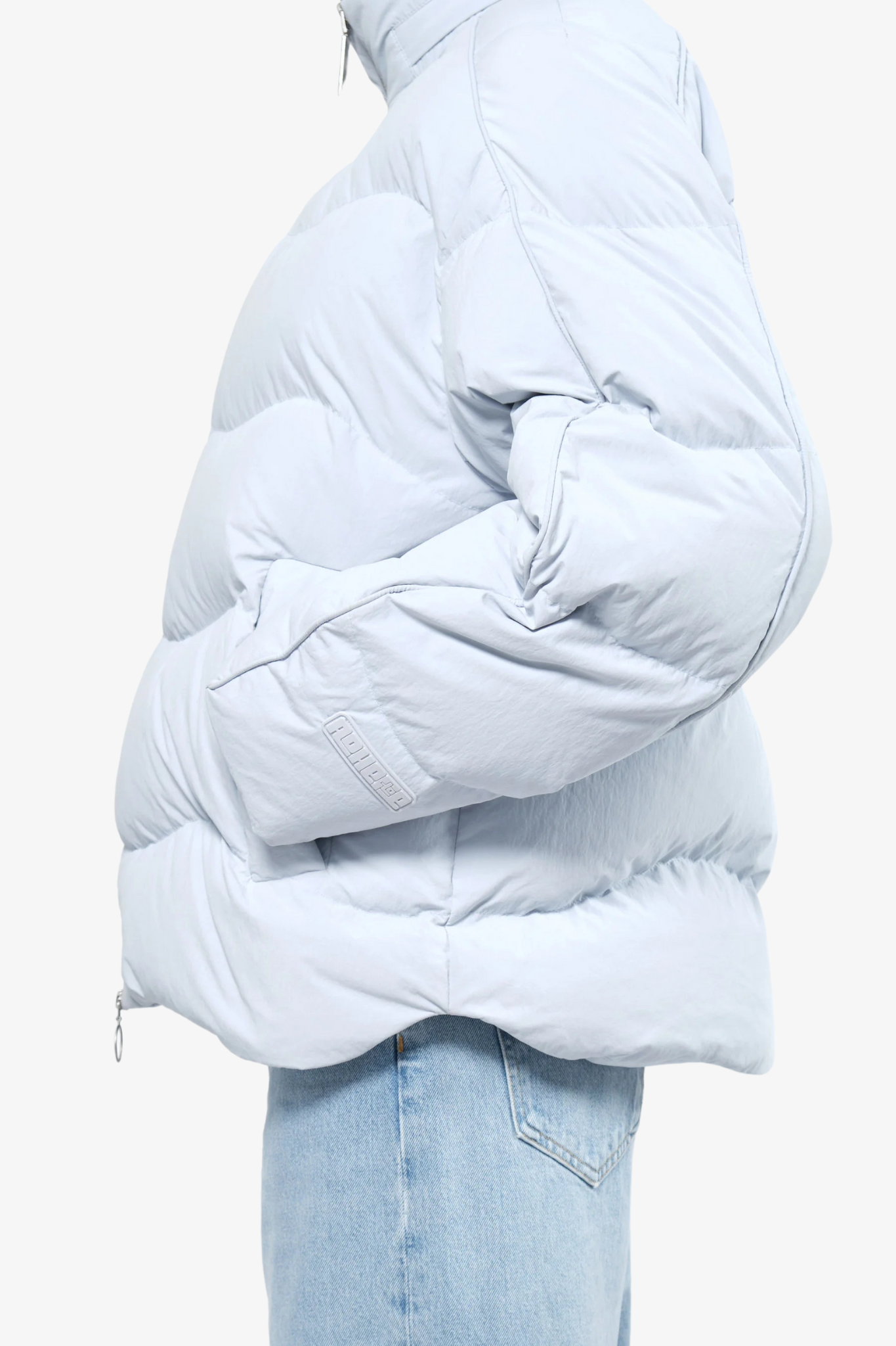 Close-up of model wearing a puffer jacket in a white background. 100% made from recycled fabric. 