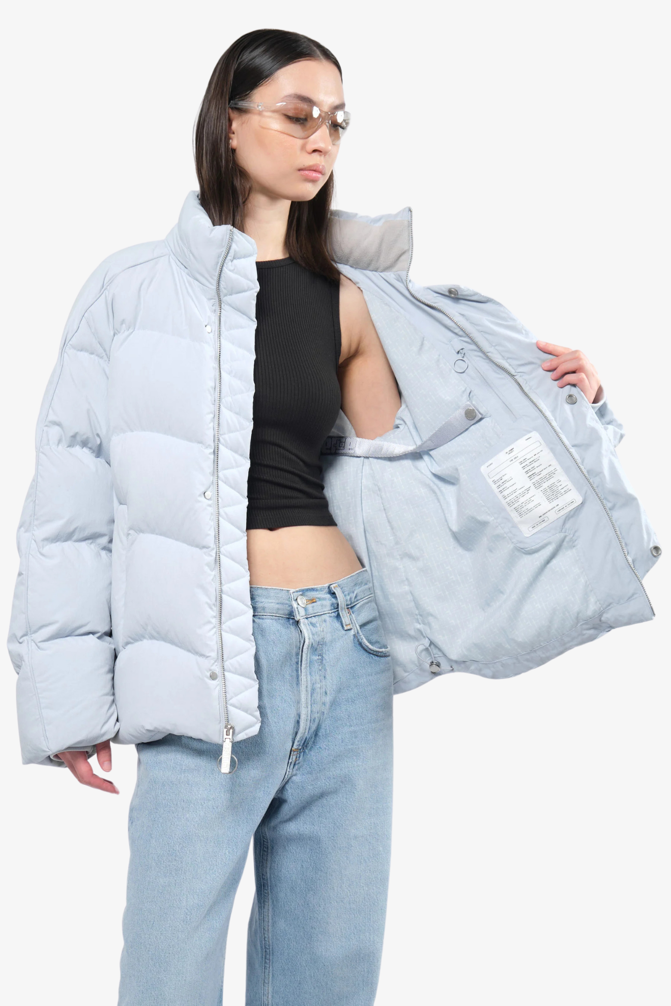 Model wearing a puffer jacket in a white background. 100% made from recycled fabric. 