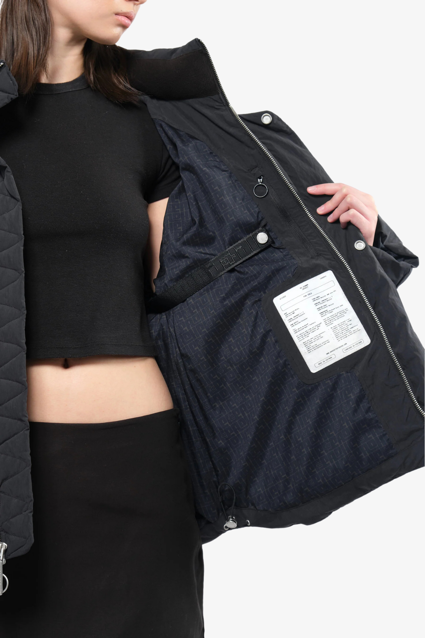 Close-up of model wearing a puffer jacket in a white background. 100% made from recycled fabric. 