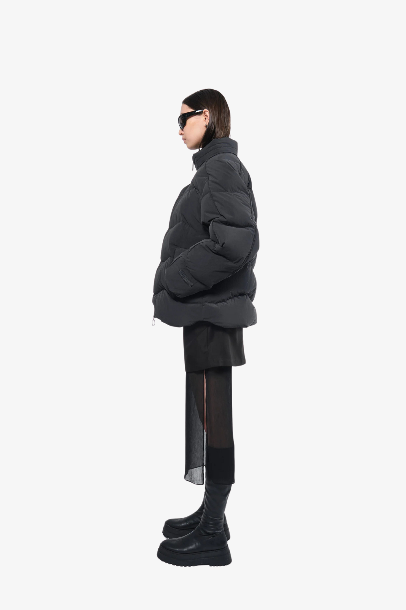 Model wearing a puffer jacket in a white background. 100% made from recycled fabric. 
