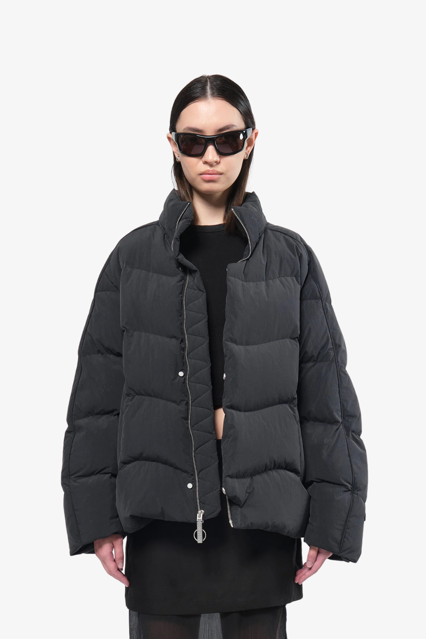 Model wearing a puffer jacket in a white background. 100% made from recycled fabric. 