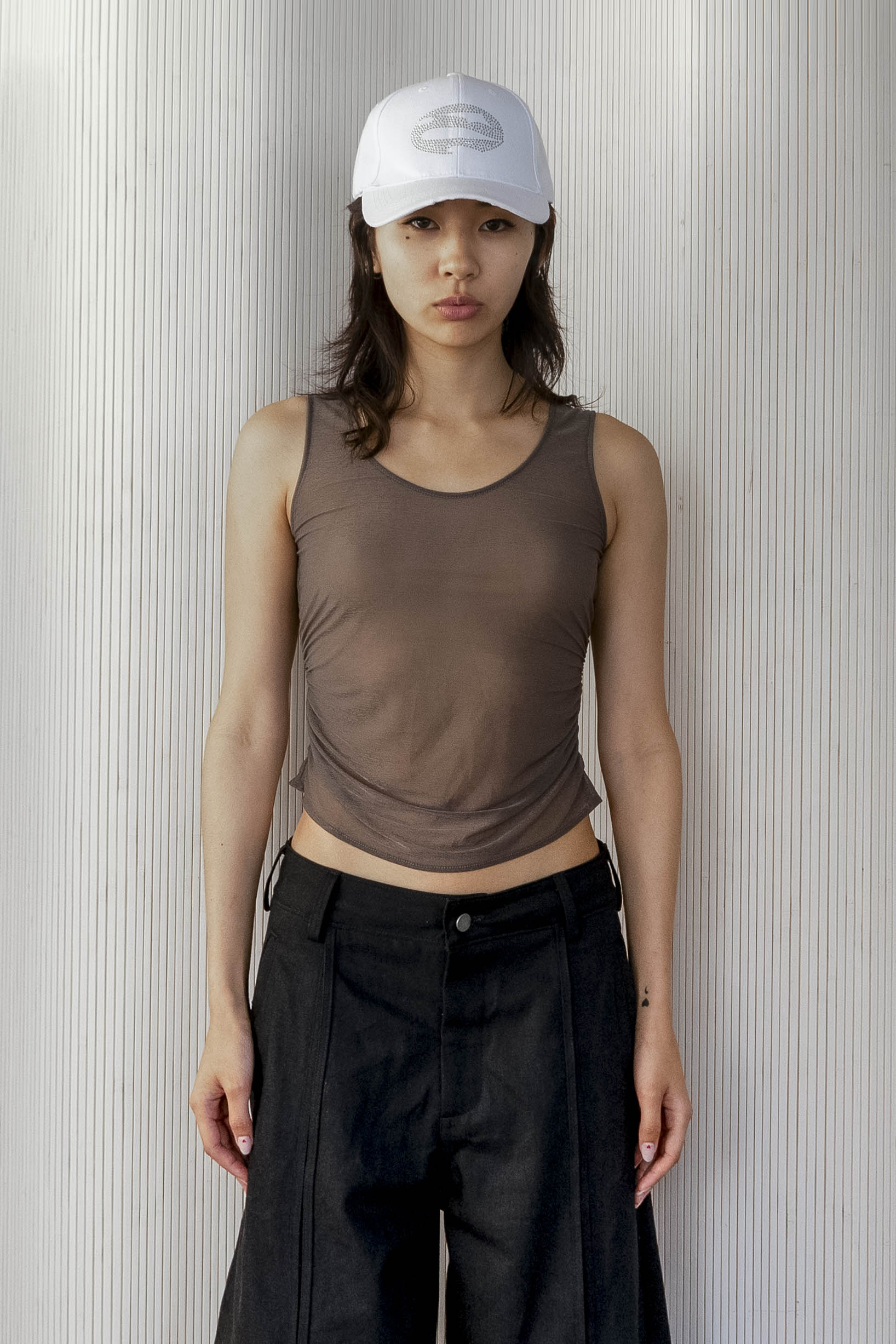 A model wearing the ruched sheer tank in an aesthetically background. 100% deadstock, Japanese sheer polyester