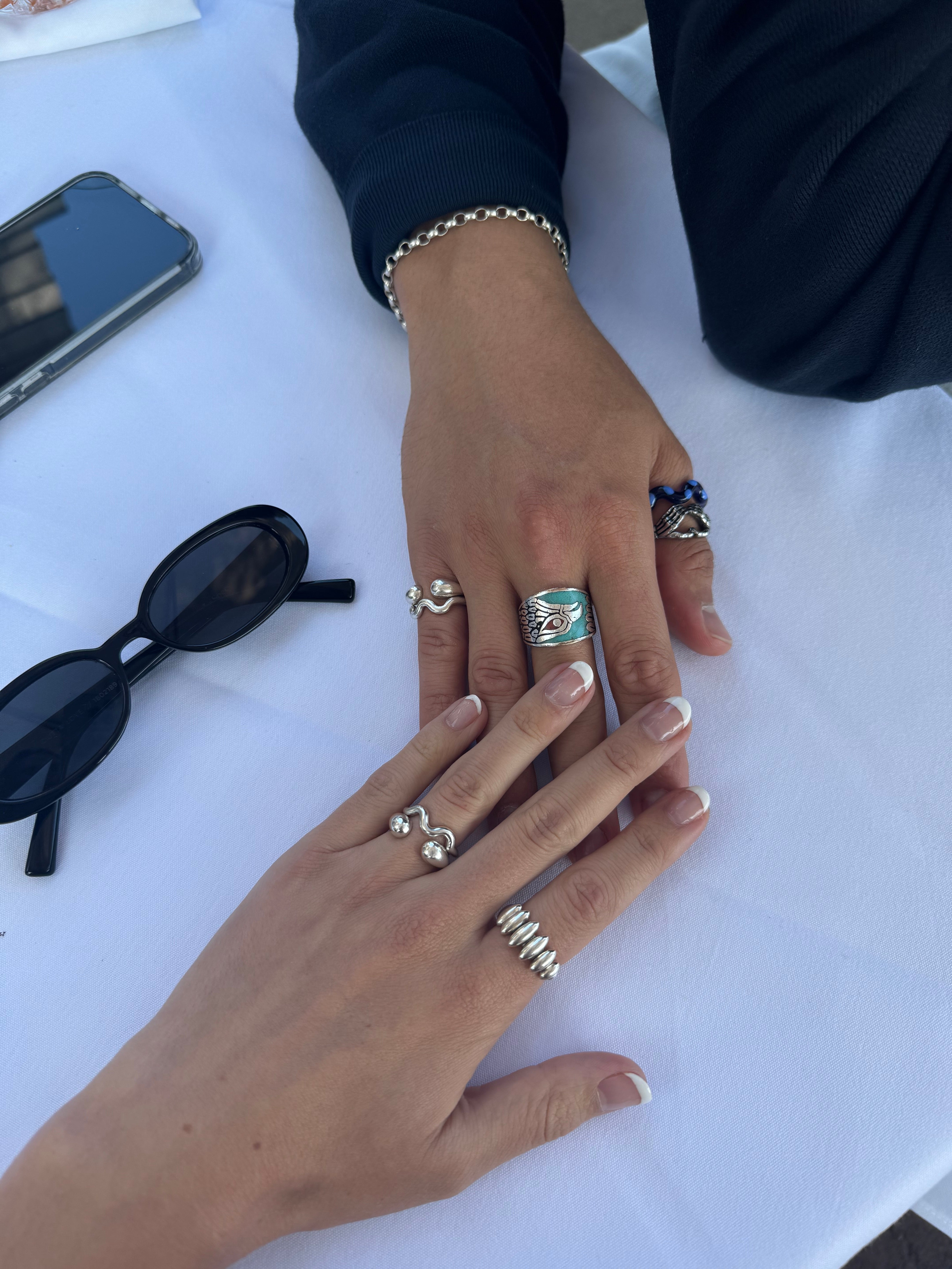 Hand models wearing the single wave silver ring. Made from 100% recycled metals